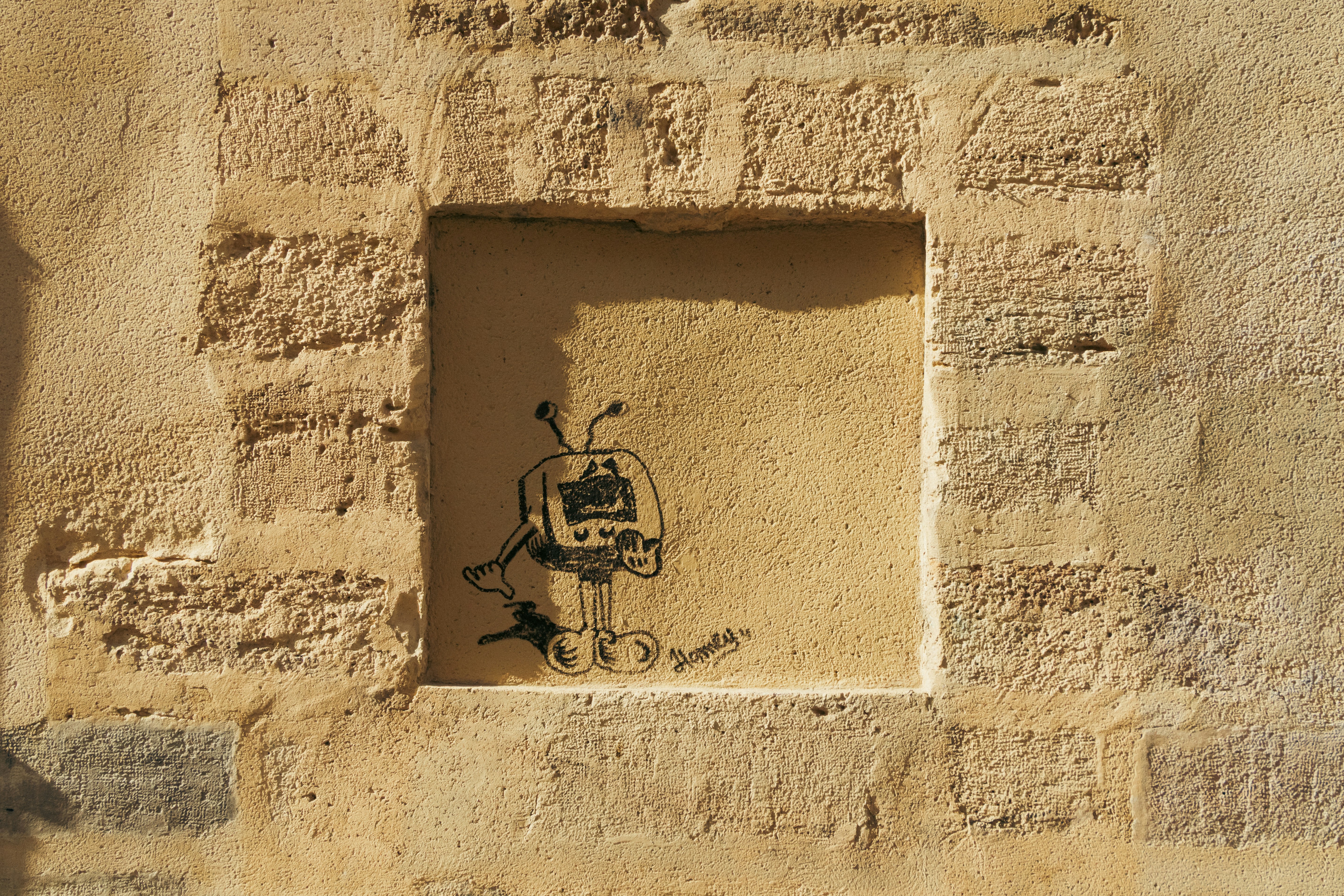 Graffiti of a robot inside a stone window frame