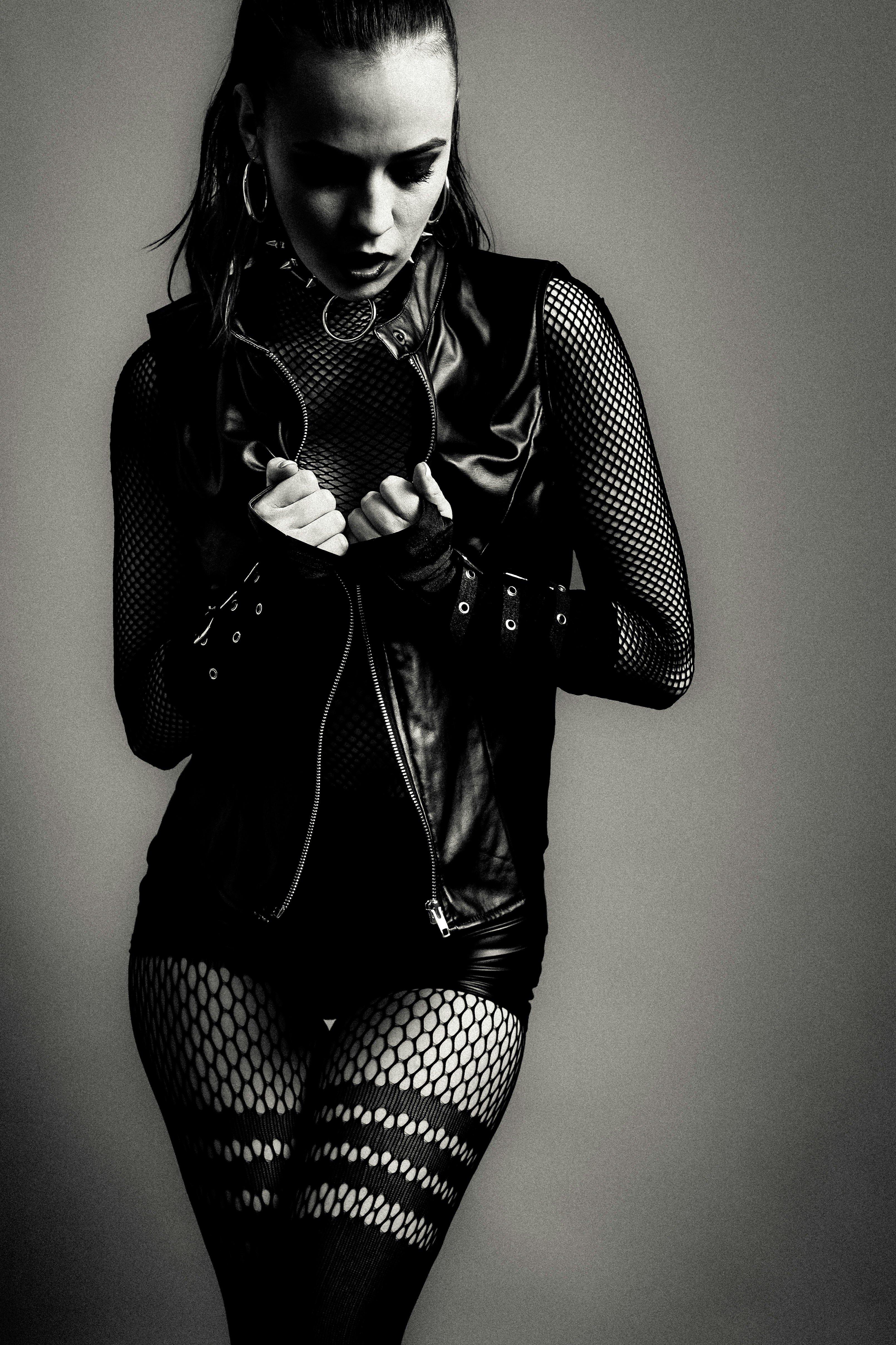 Frau in Lederjacke und Netzstrümpfen