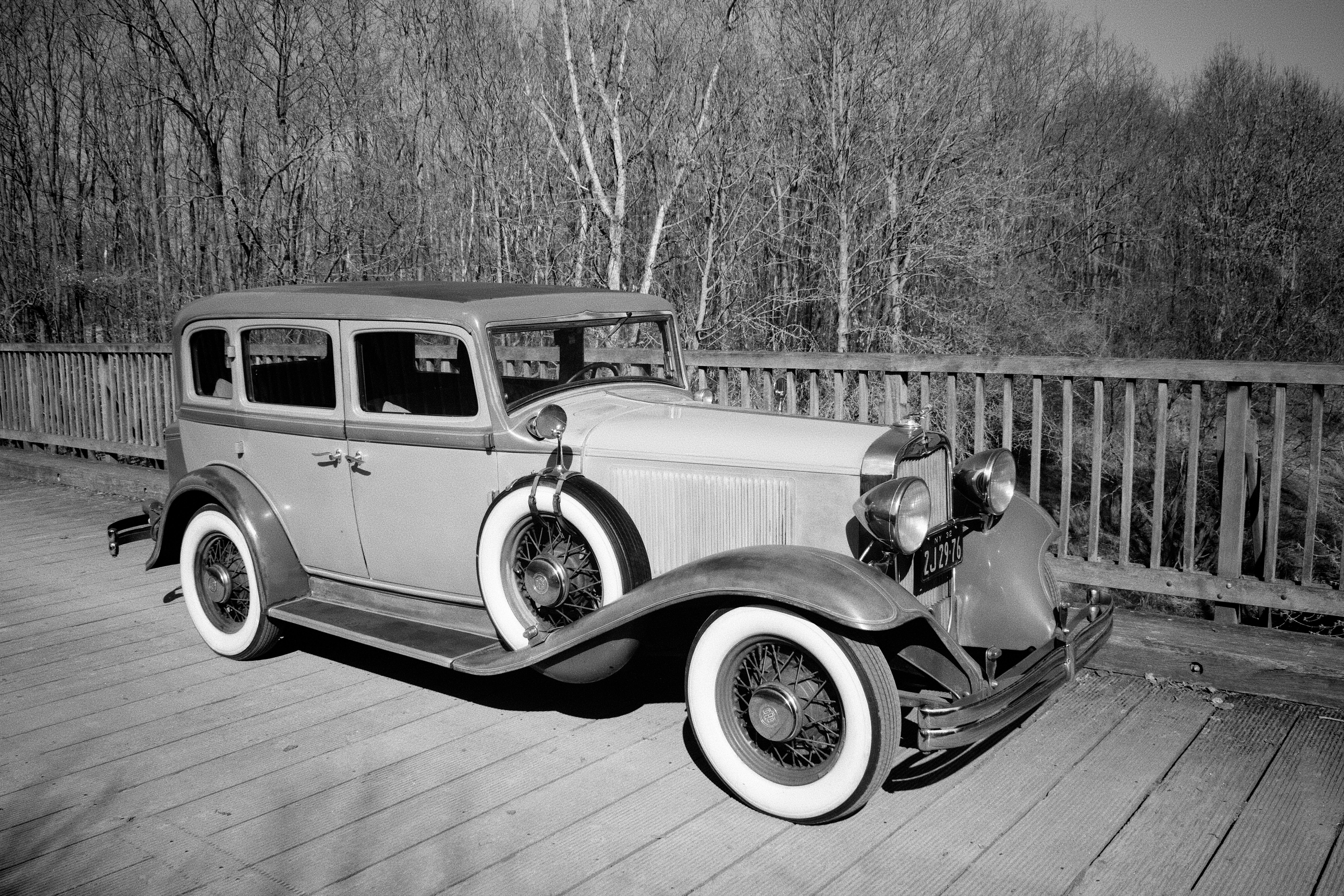 Vintage car parked on a wooden bridge.