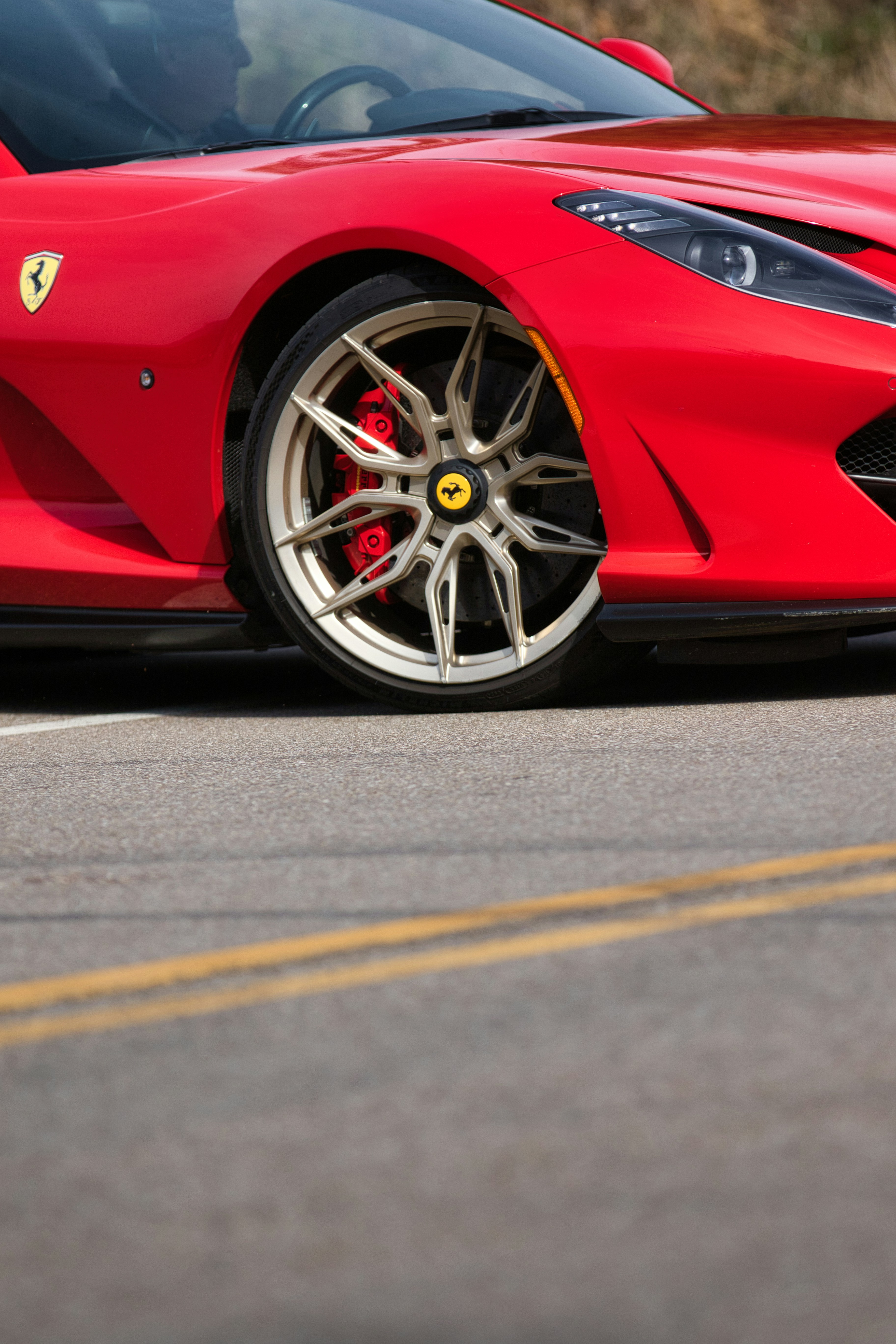 Red sports car wheel on a road