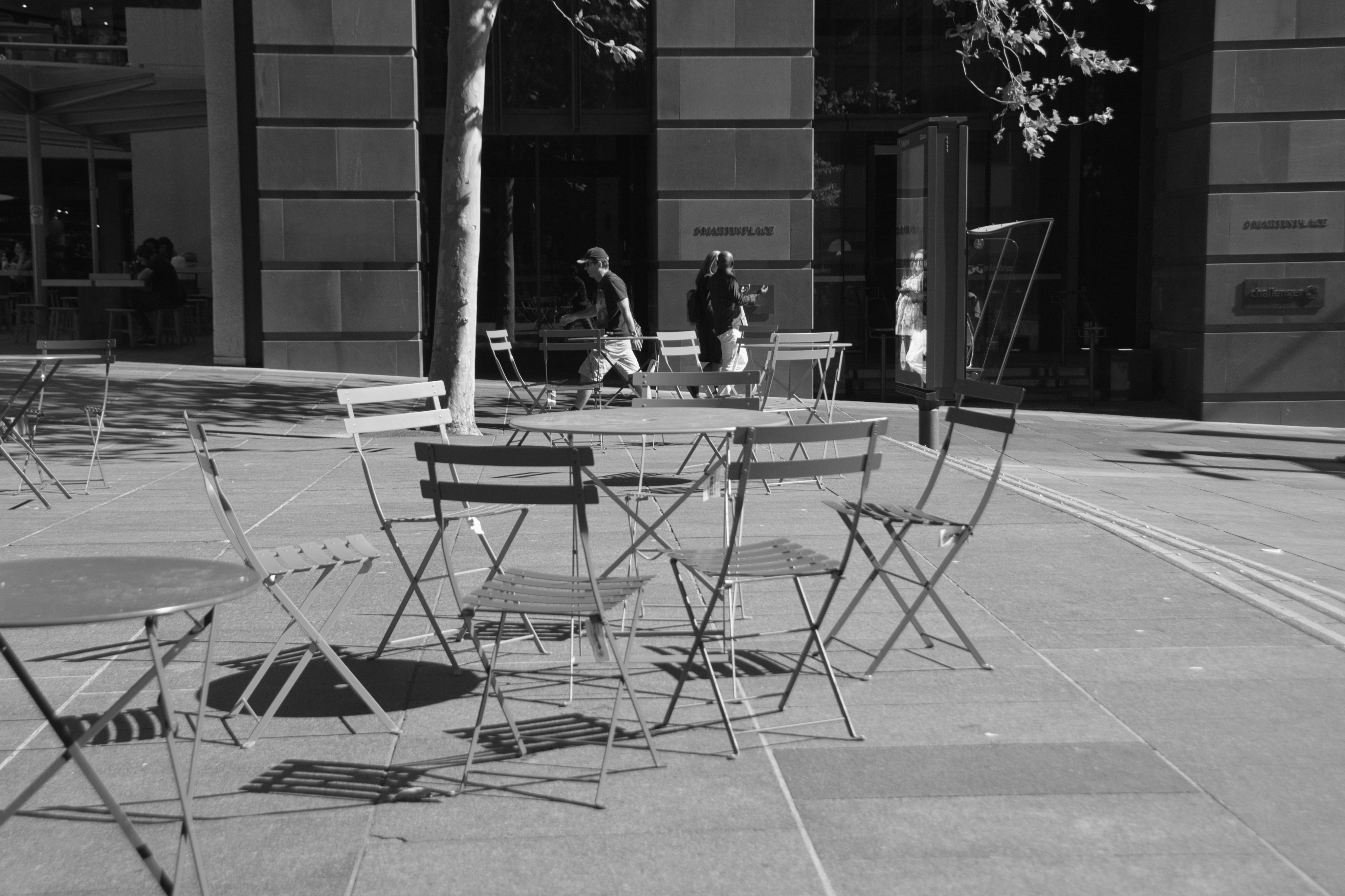 Outdoor cafe tables and chairs with people in background