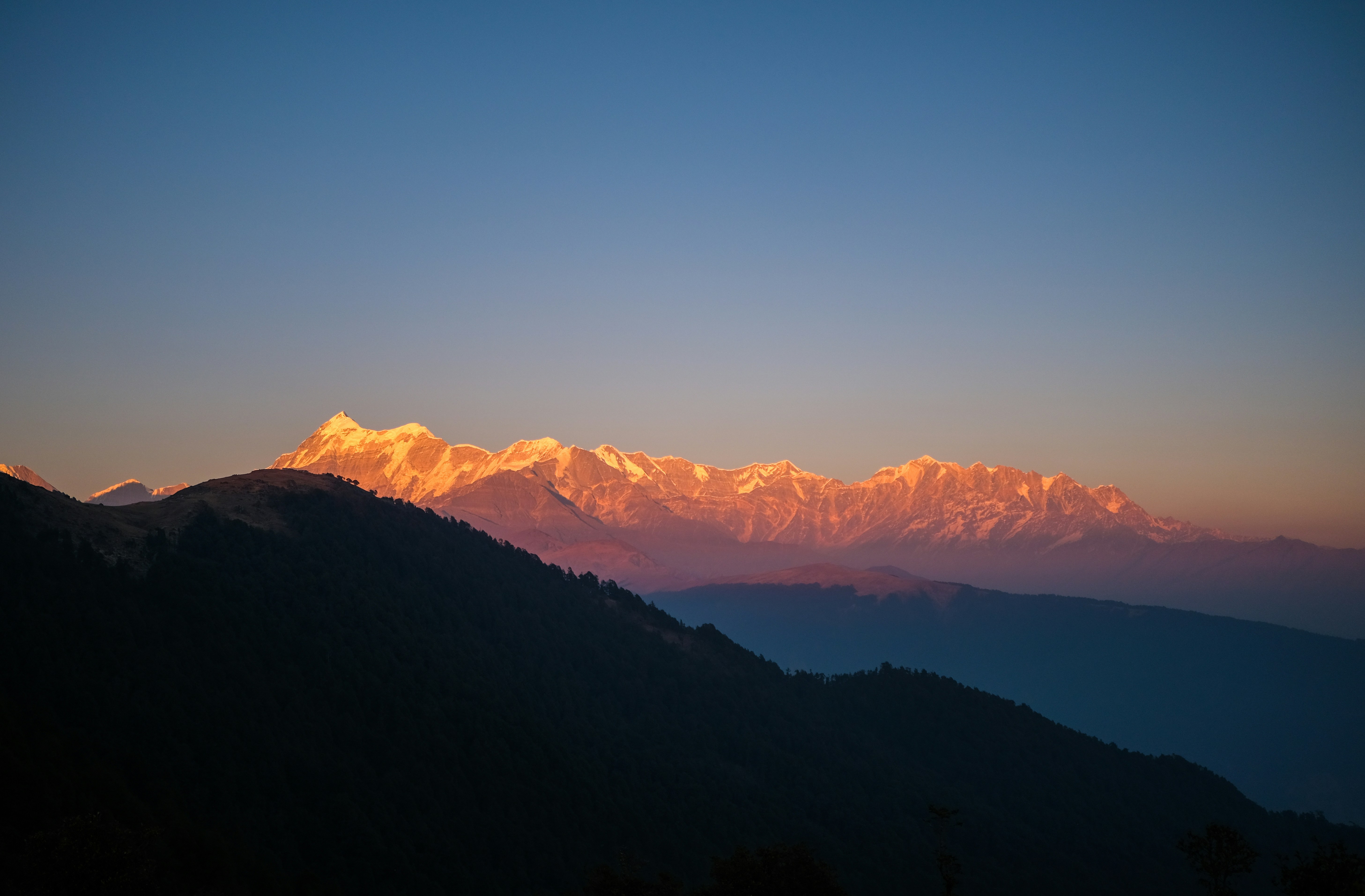 Snow peaks lit gold by the setting sun