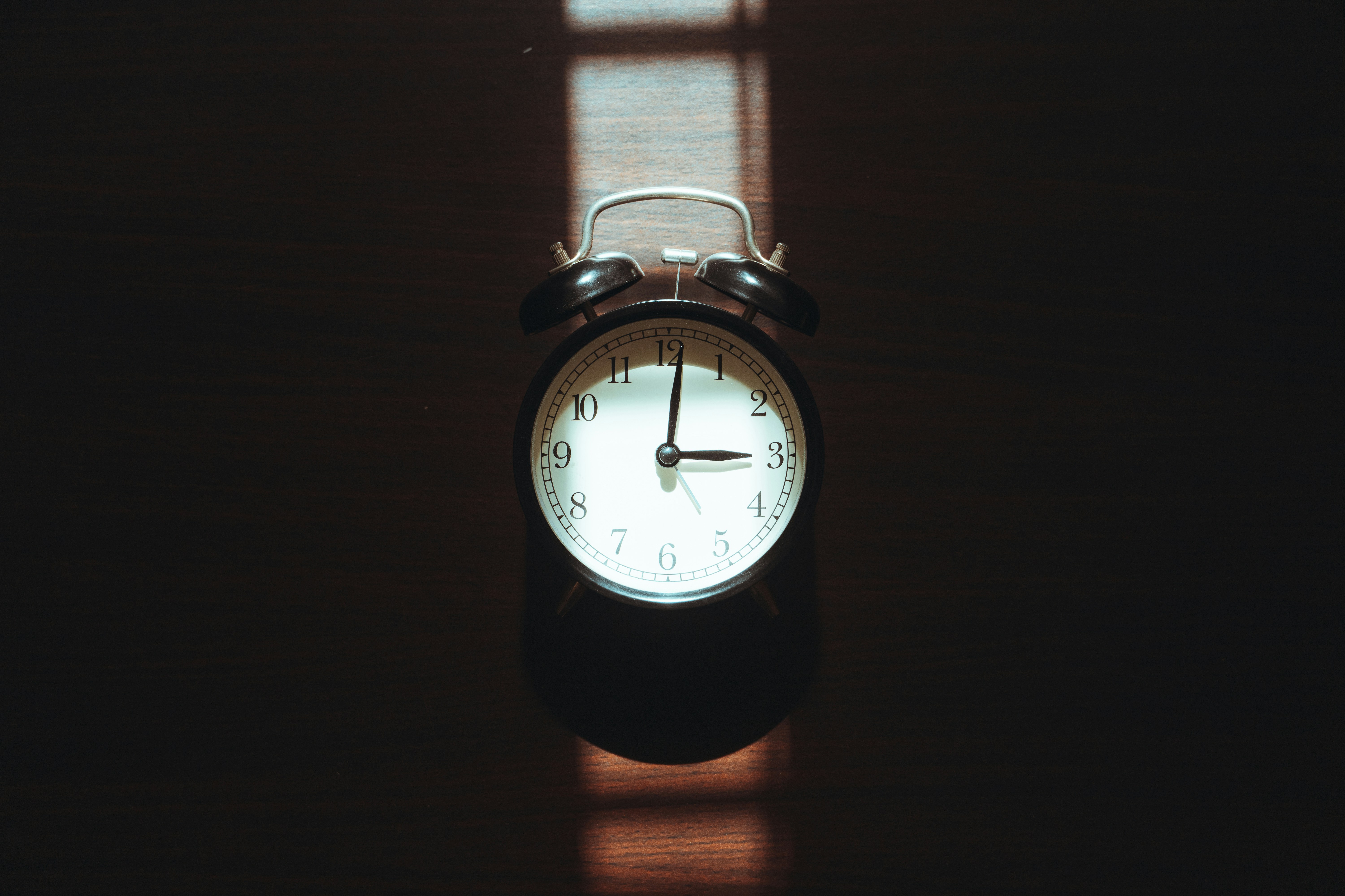Alarm clock casting a shadow on a dark surface