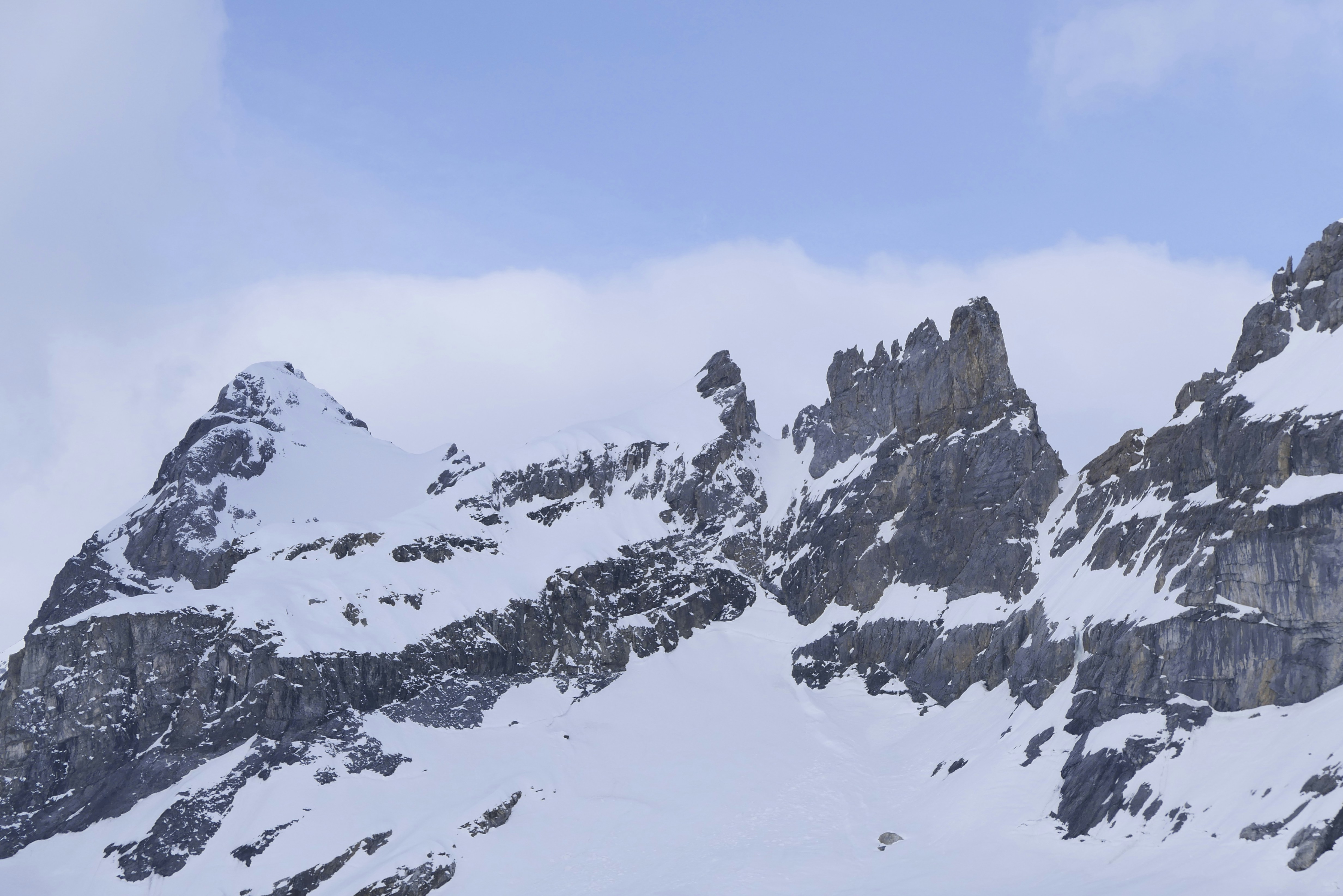 Snow-covered mountains under a cloudy sky