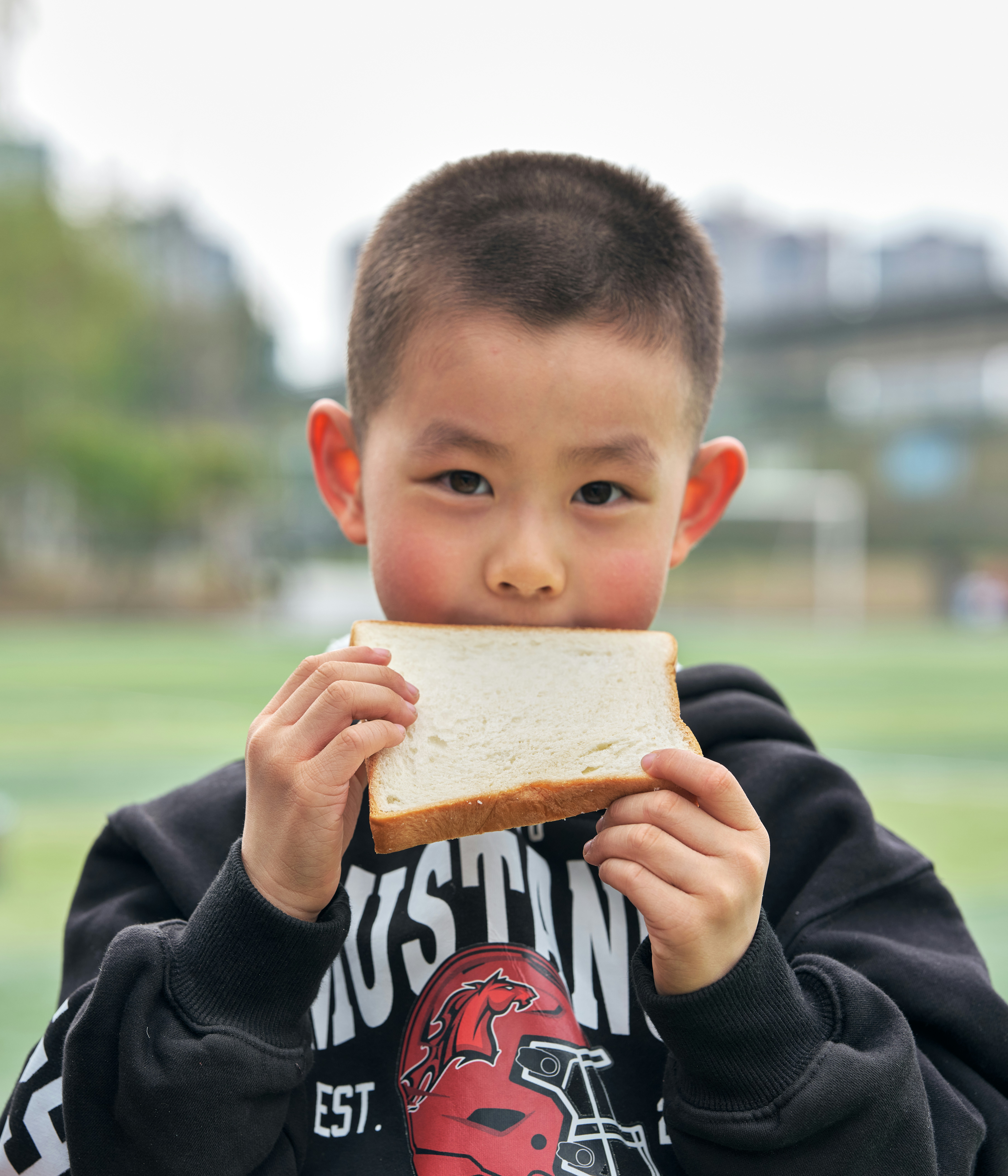 Young boy eating a slice of white bread