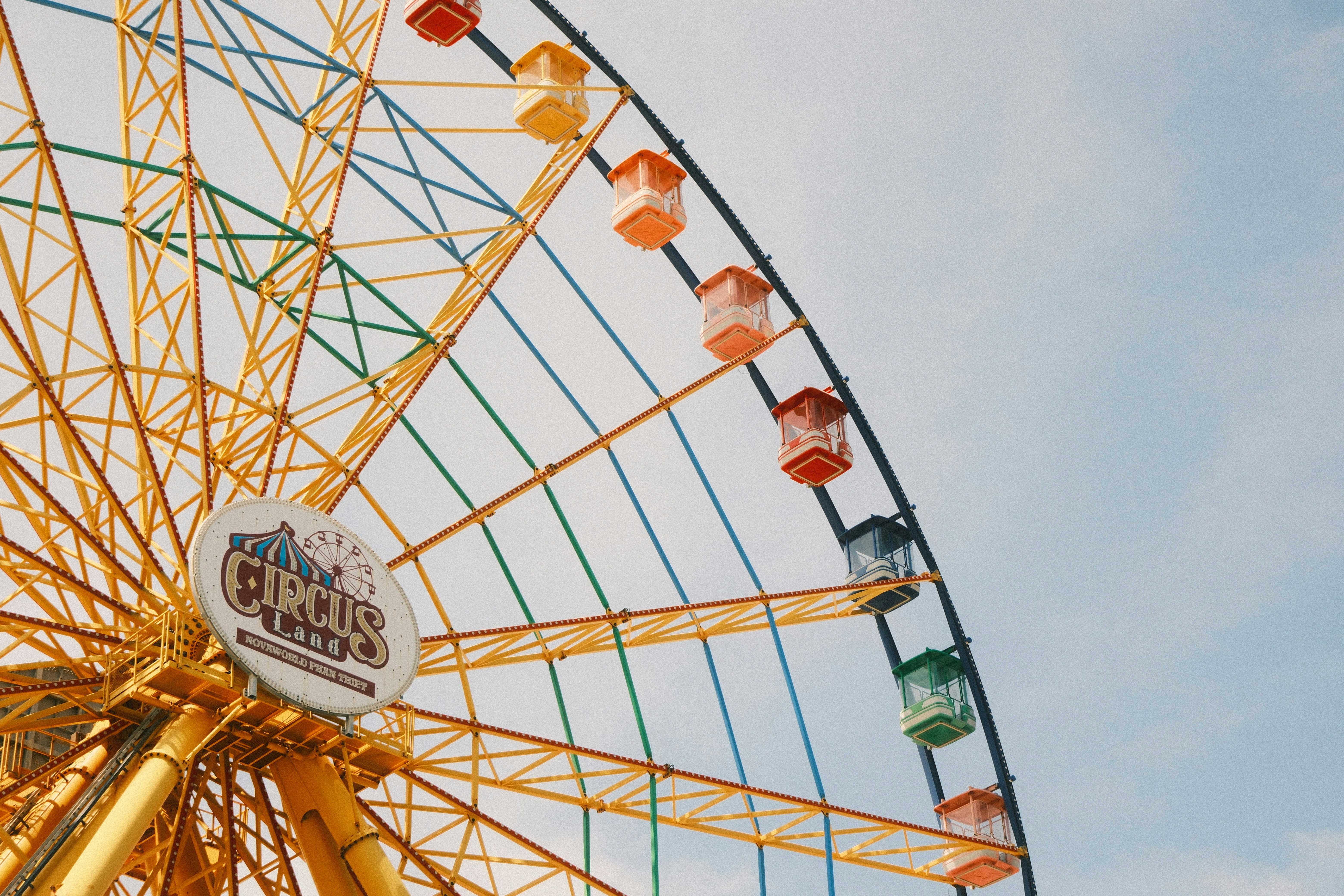 Colorful ferris wheel against a pale blue sky