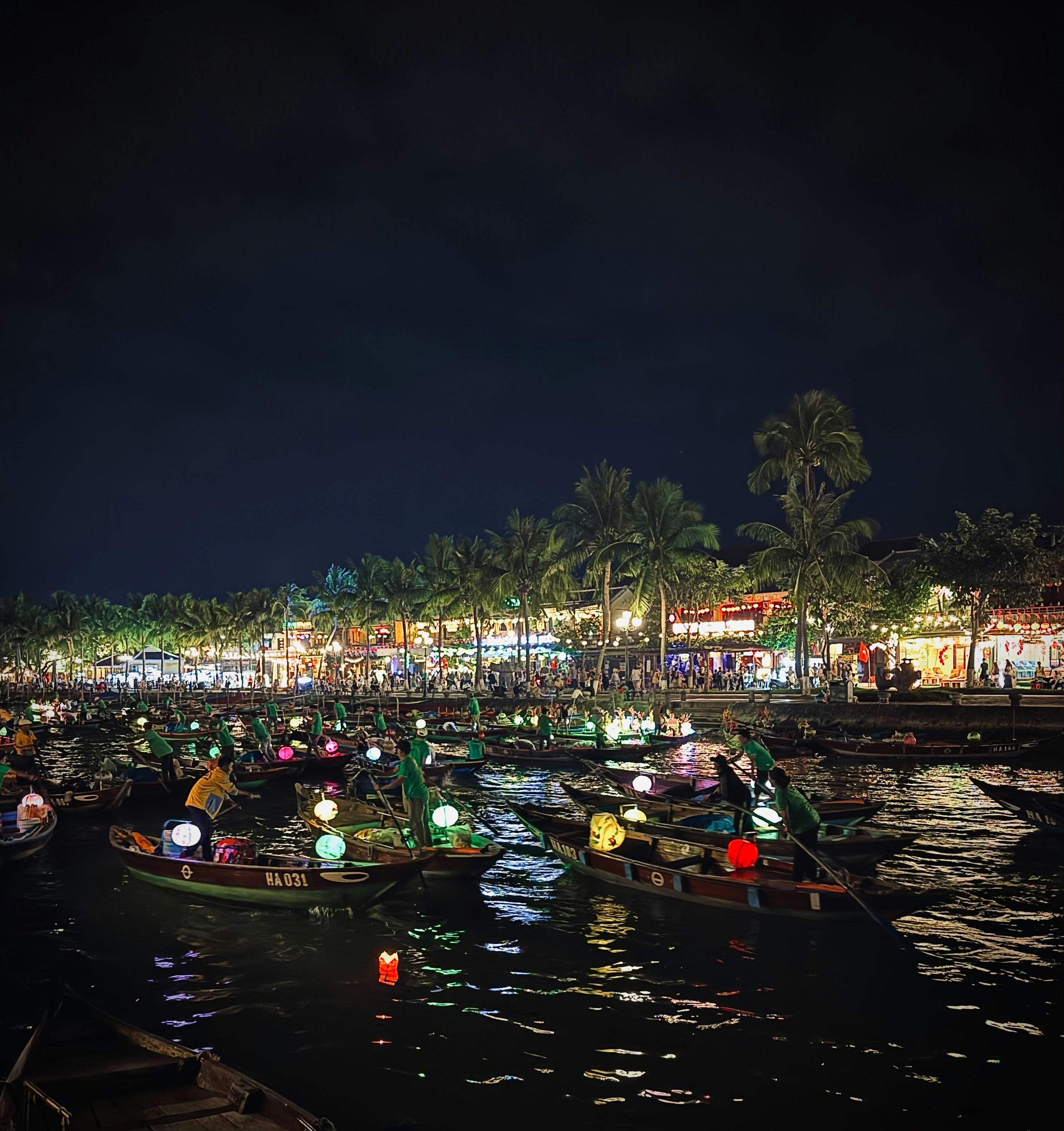 Boats with lanterns on a river at night