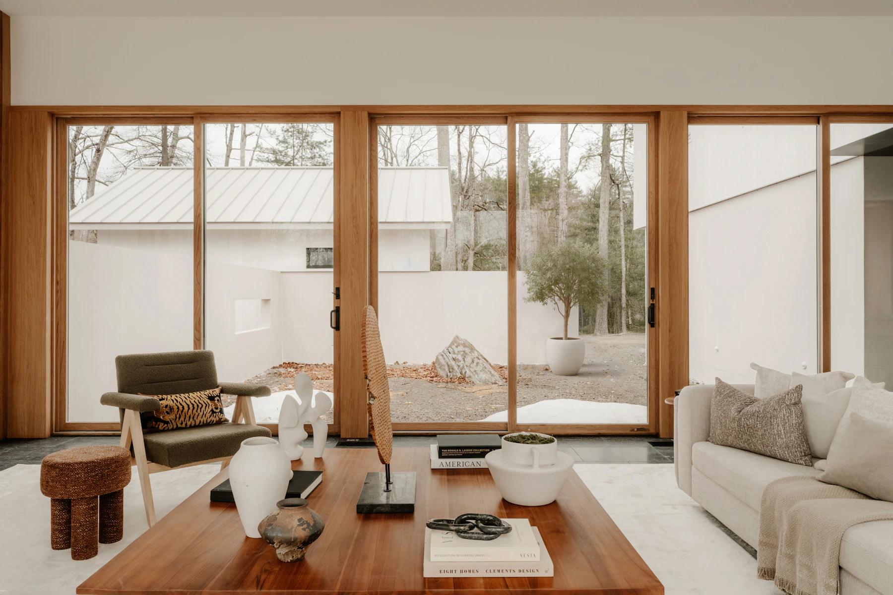 Warm wood and natural light in a living room opening onto a quiet courtyard