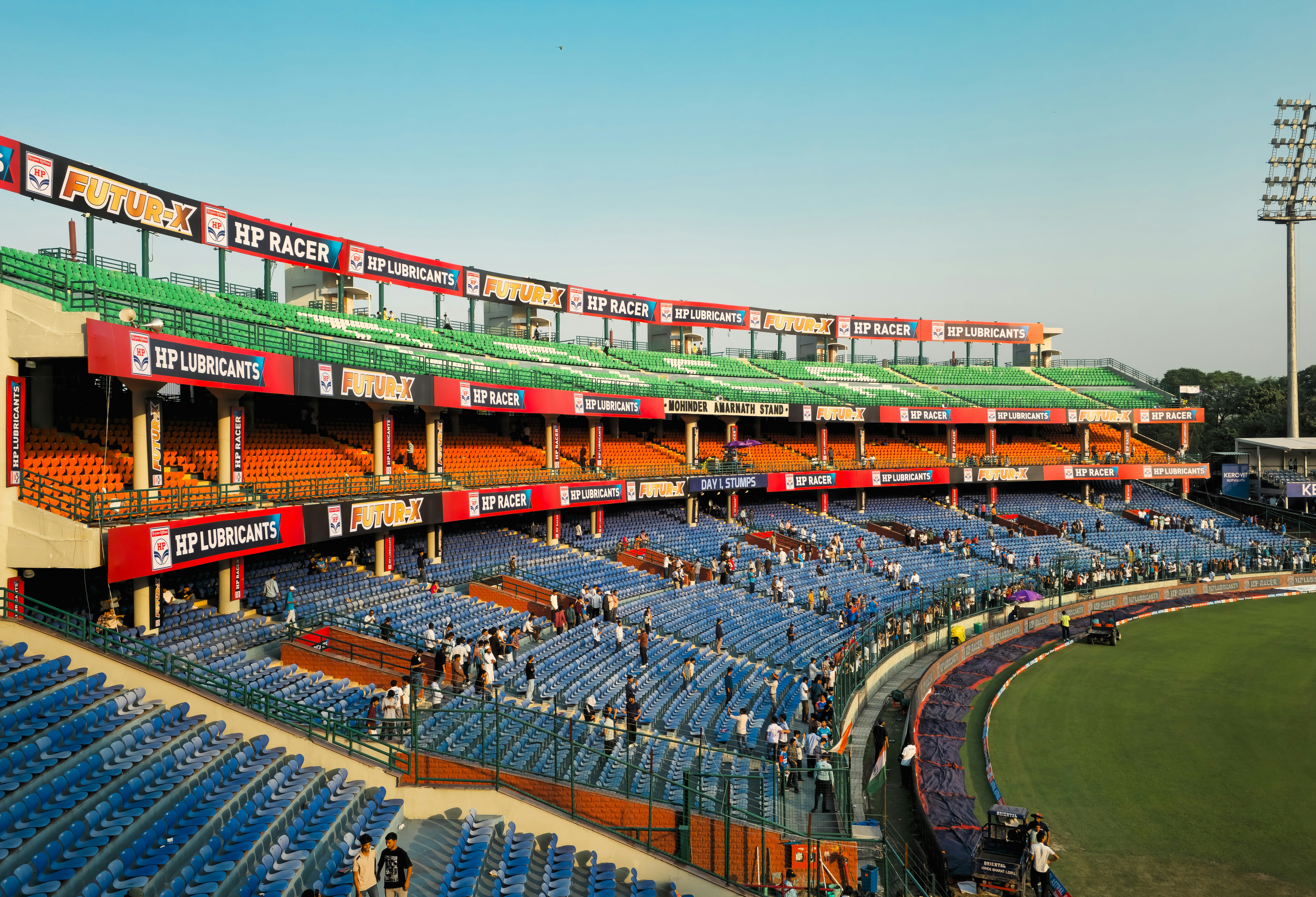 Empty blue stadium seats under a bright sky