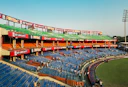 Empty blue stadium seats under a bright sky