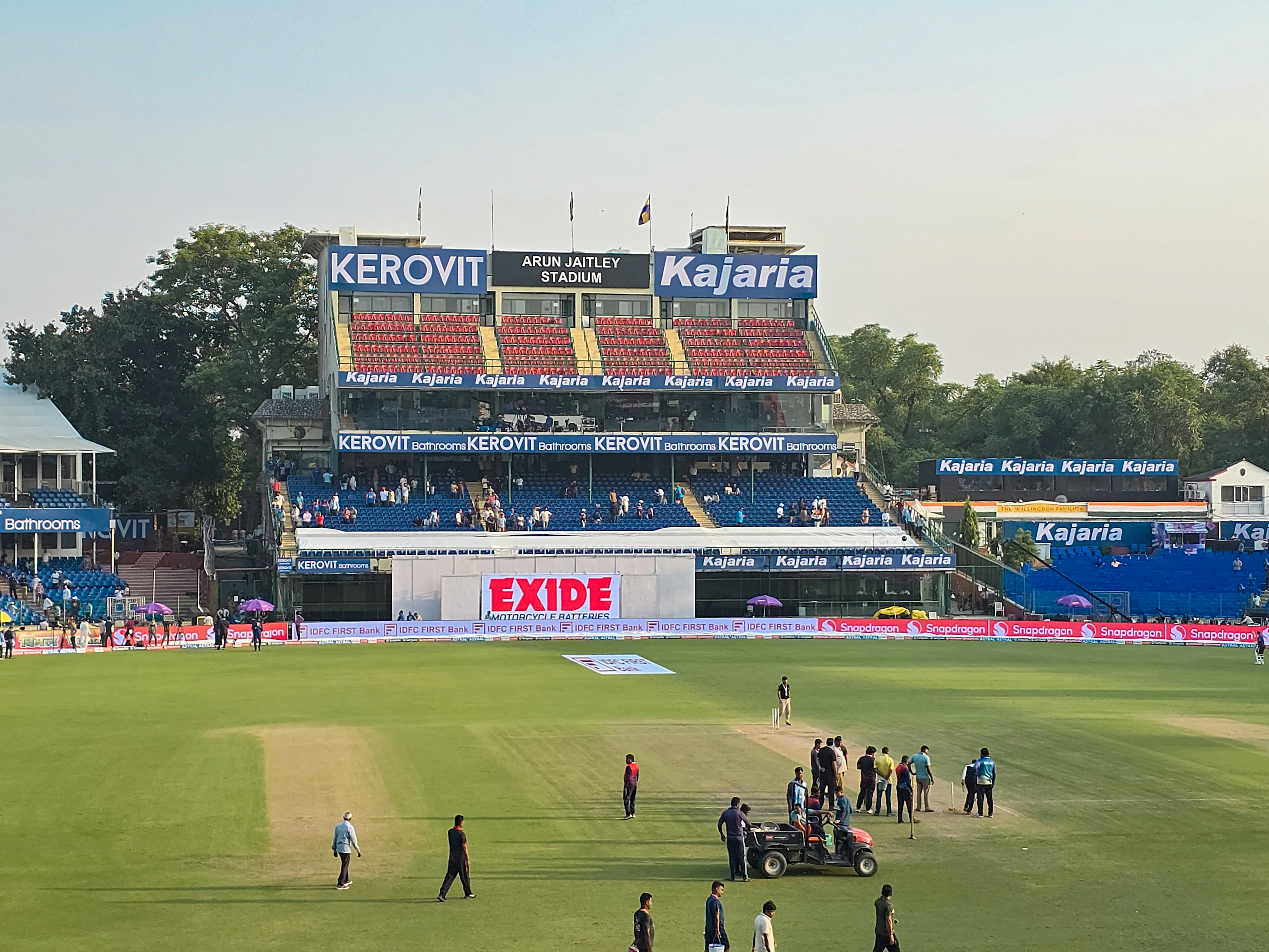 A cricket match underway in a busy stadium