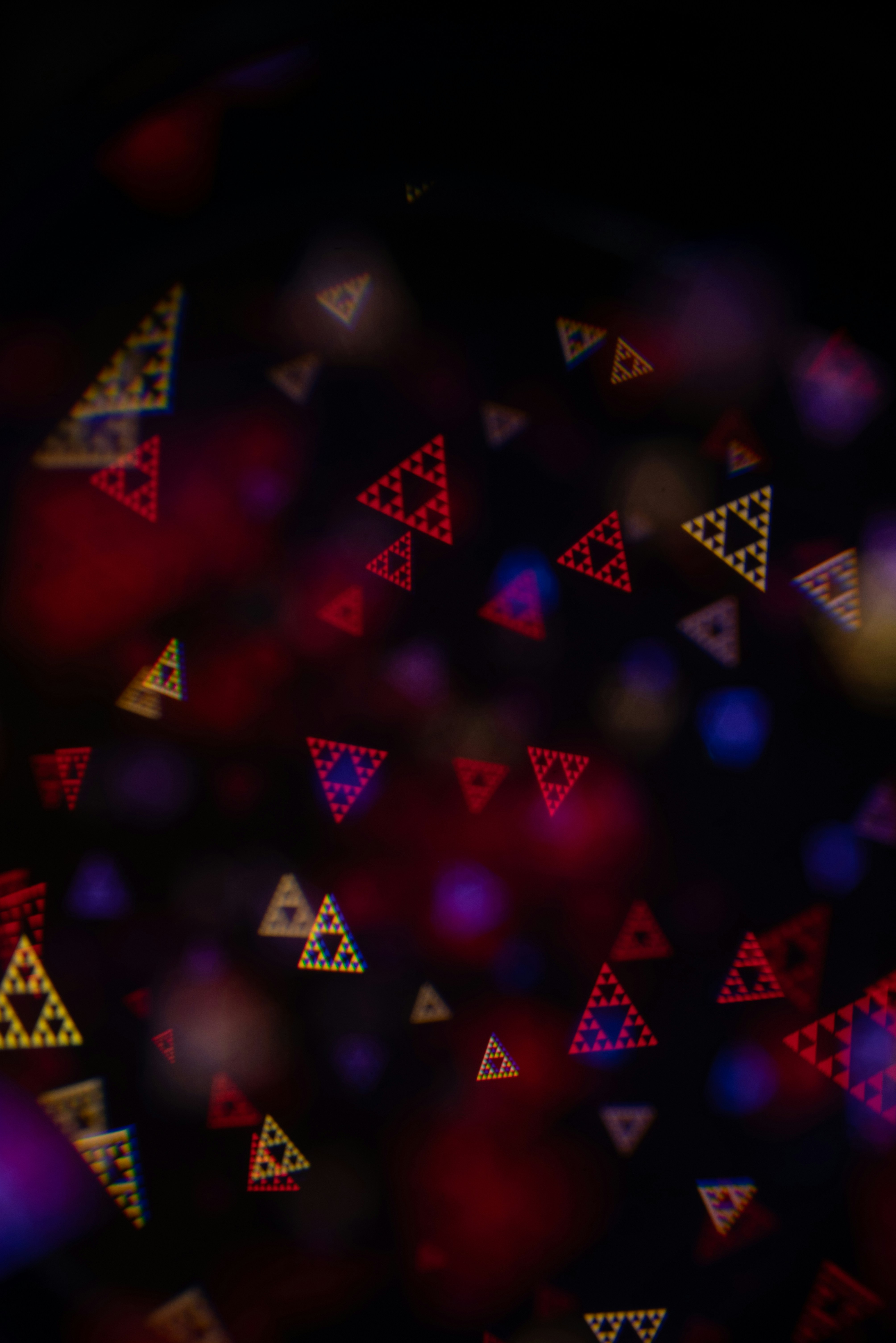Abstract background with glowing fractal triangles and bokeh lights