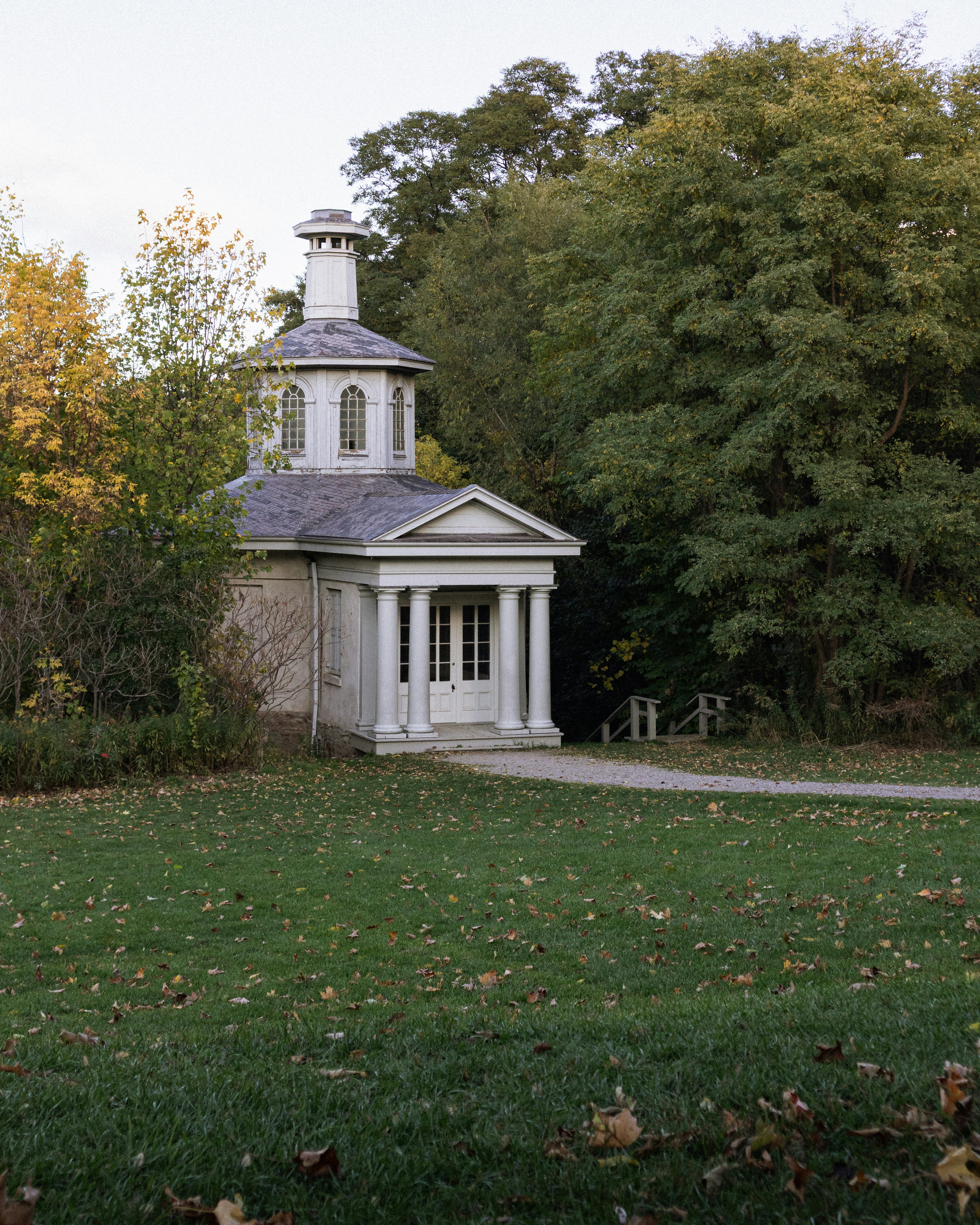 Small classical building with a dome surrounded by trees