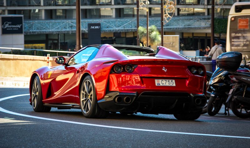 A shiny red Ferrari convertible parked on a street