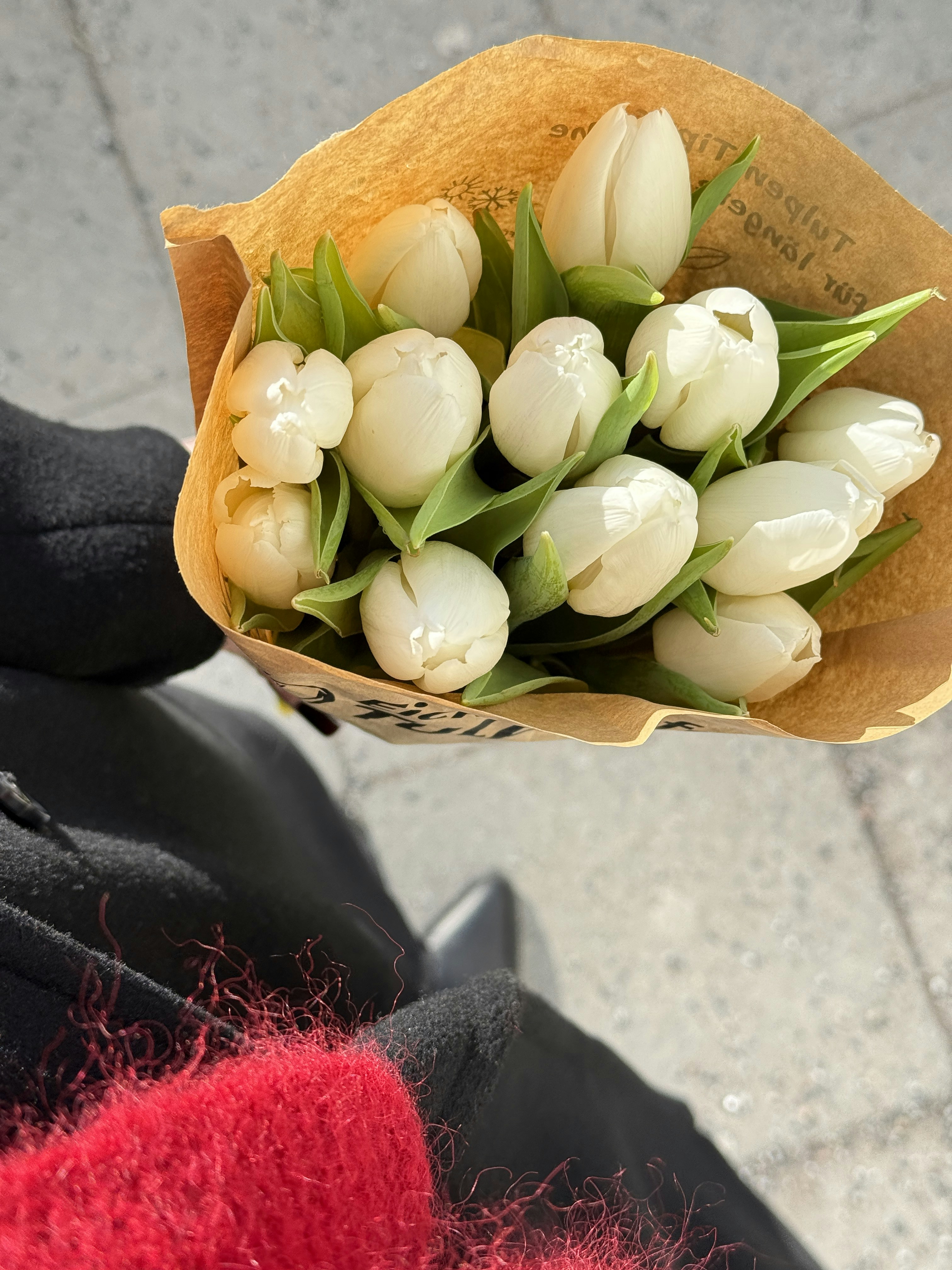 Um buquê de tulipas brancas embrulhadas em papel pardo