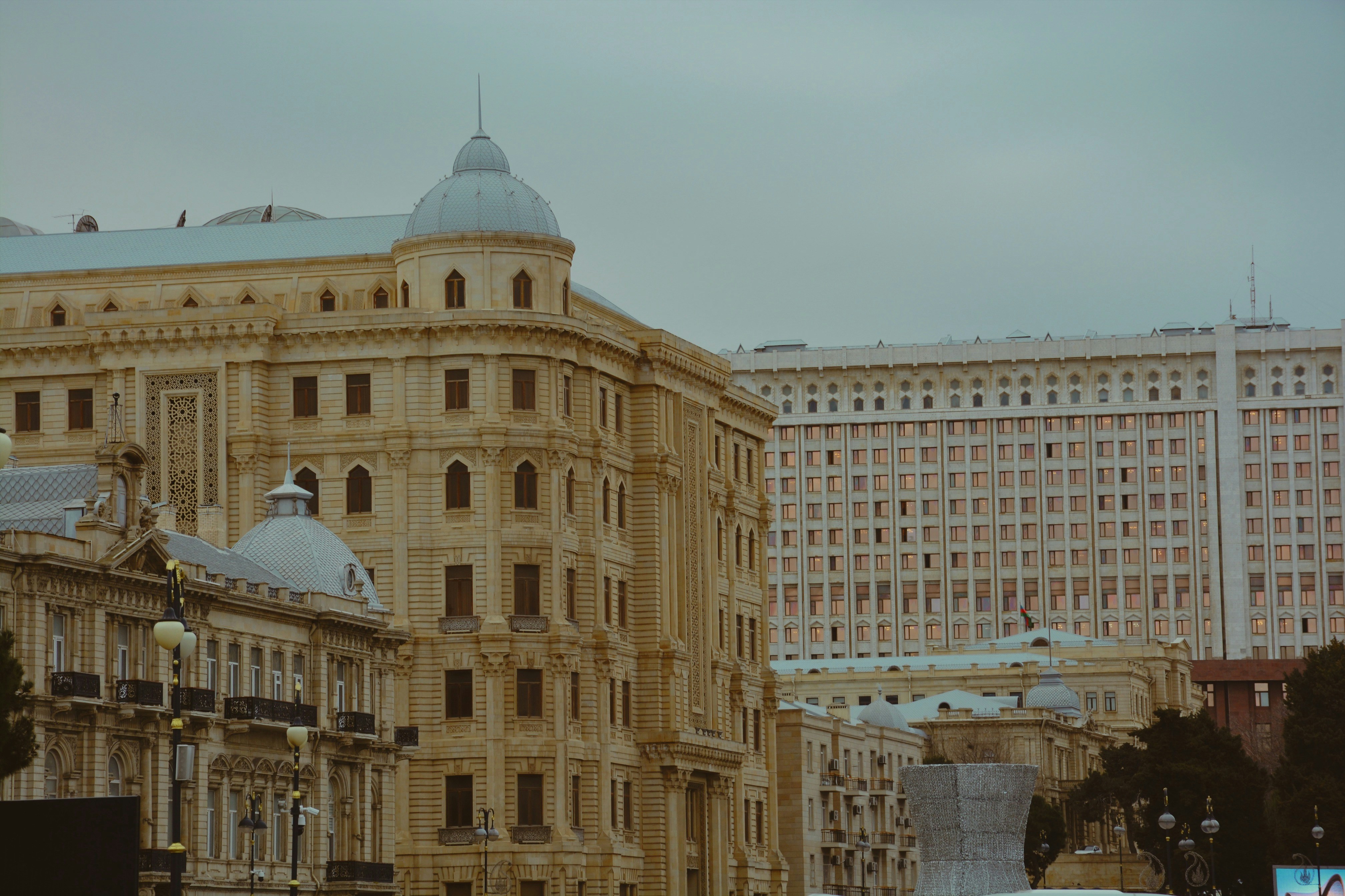A frustrated common man looking at an electricity bill, with blurred government buildings in the background, symbolizing the burden on taxpayers.