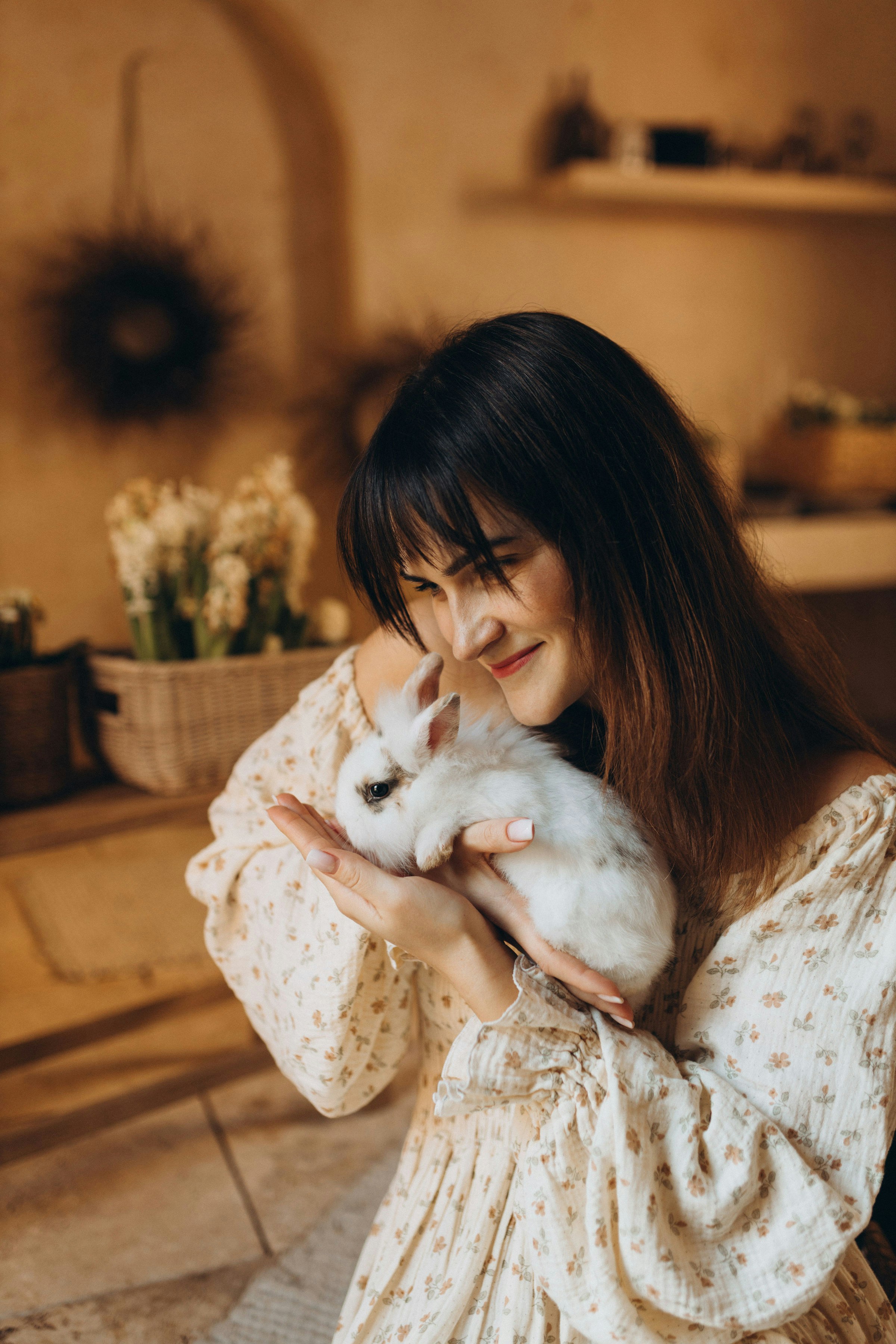 Frau hält sanft ein kleines weißes Kaninchen