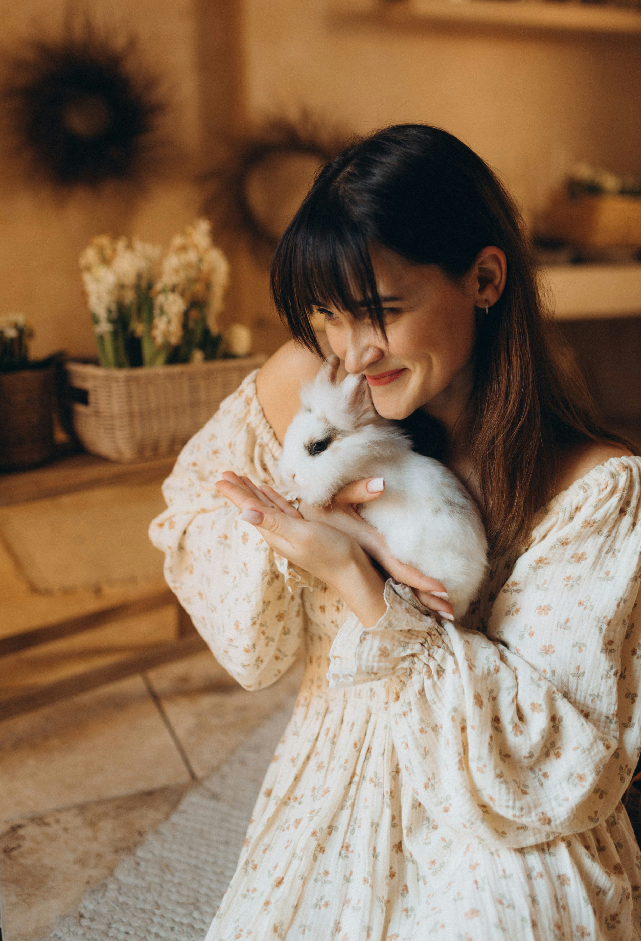 Frau, die ein weißes Kaninchen sanft hält