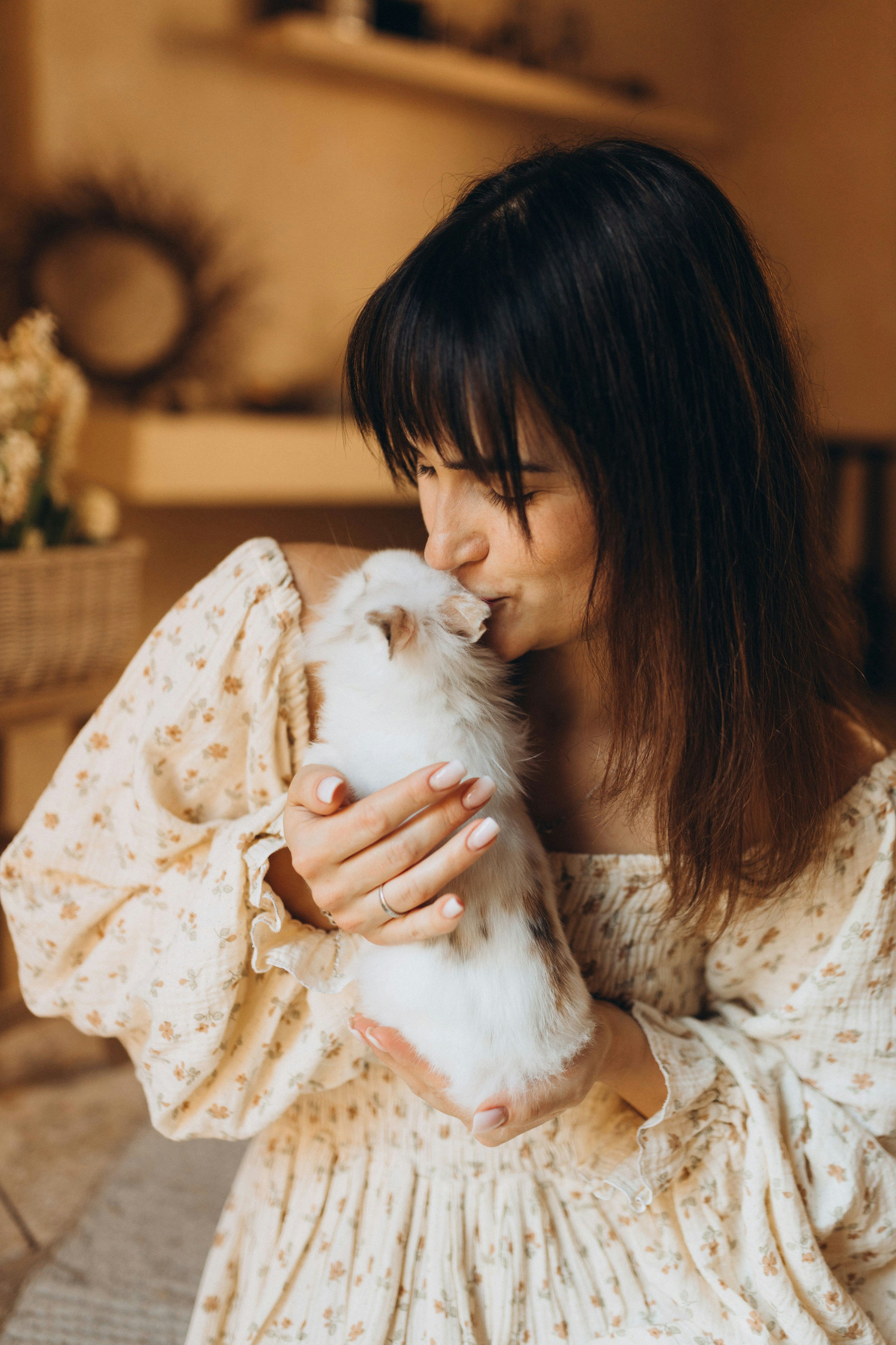 Frau, die sanft ein flauschiges Kaninchen hält und küsst