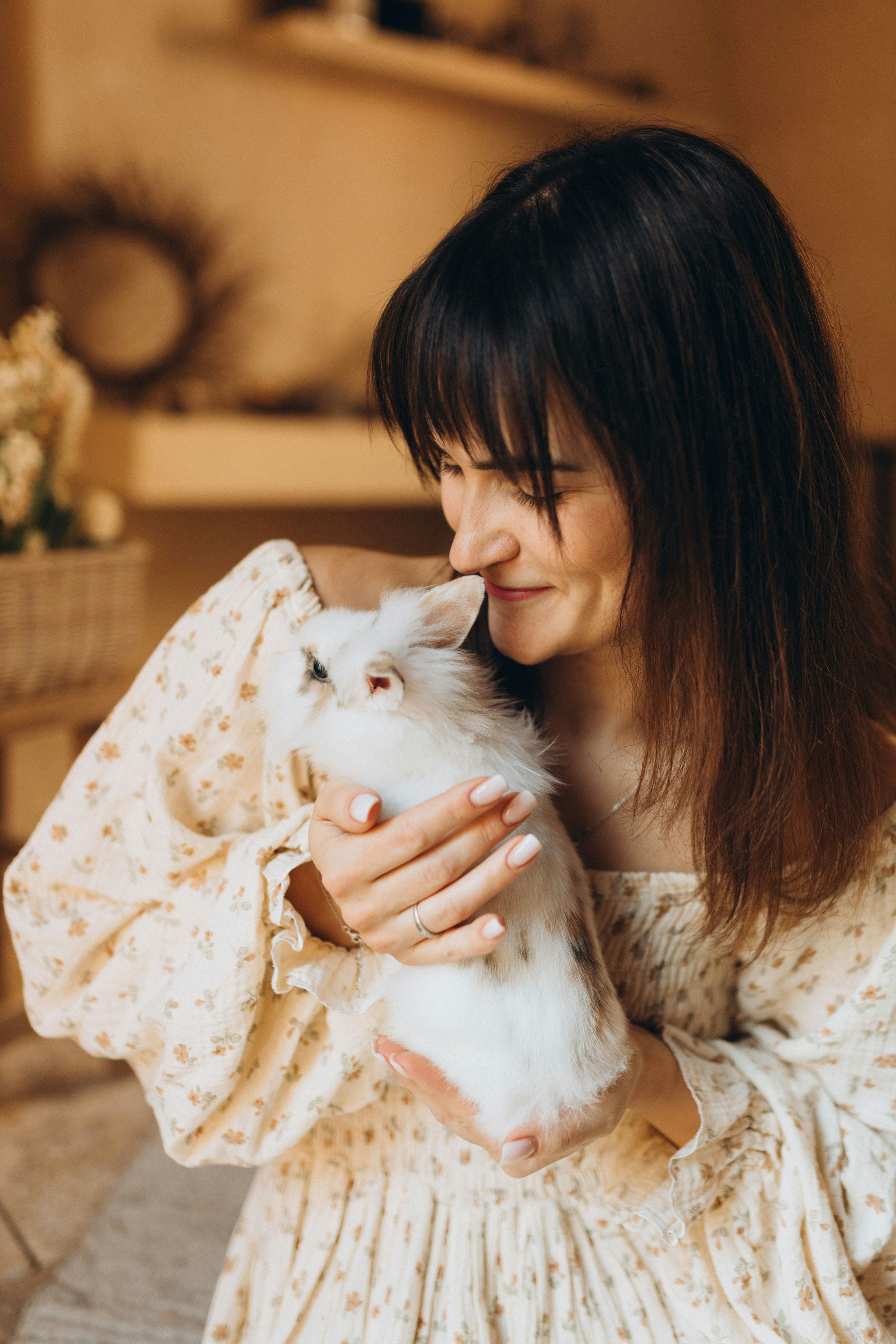Frau, die sanft ein flauschiges weißes Kaninchen hält