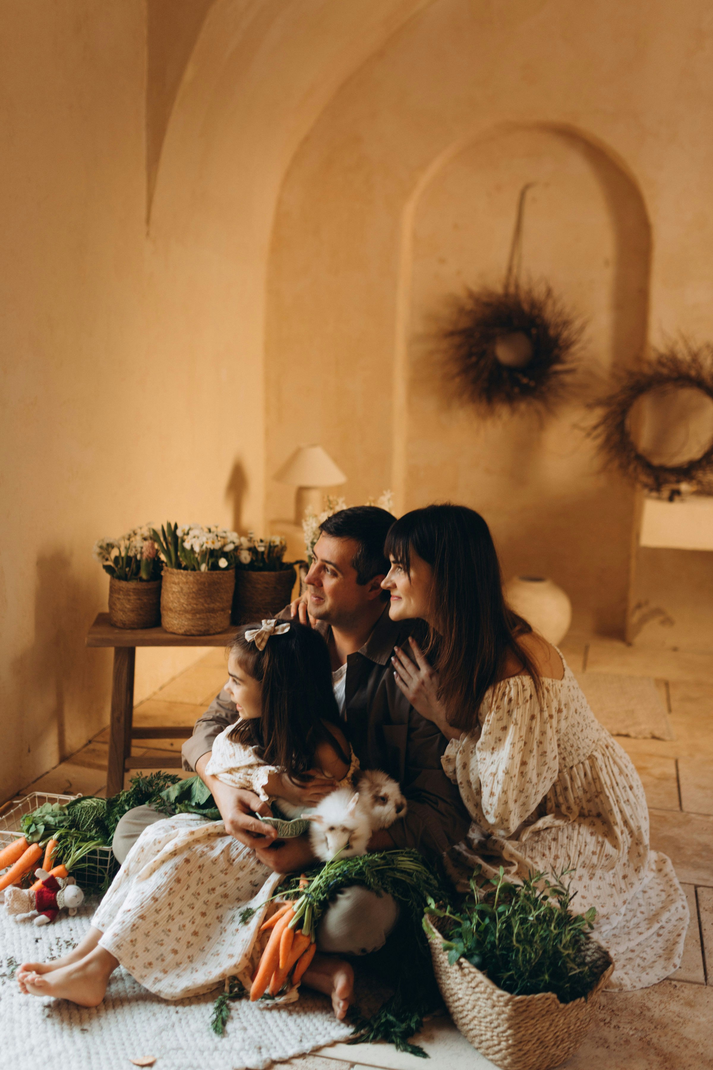 Familie mit Kaninchen und Gemüse in rustikaler Umgebung