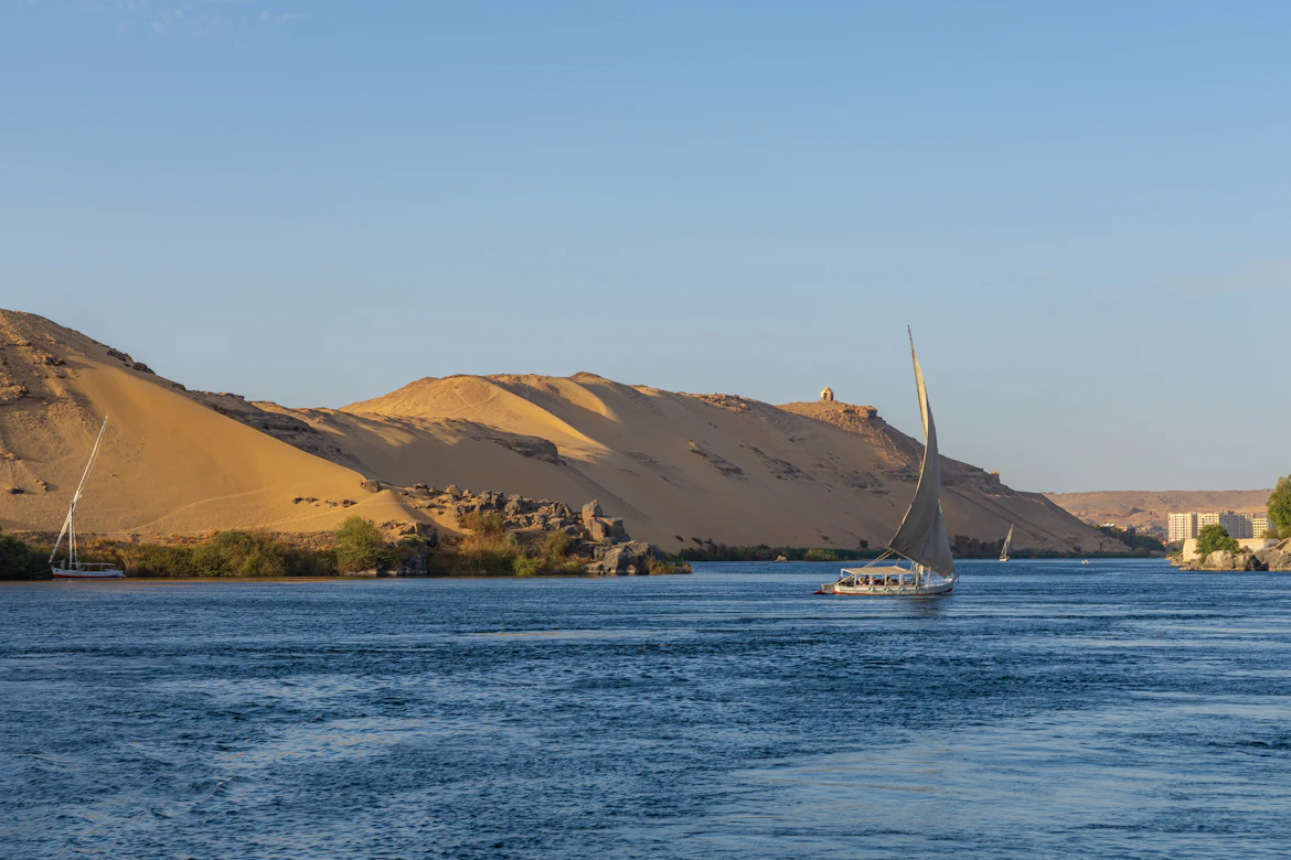 The dramatic contrast of desert dunes meeting the Nile