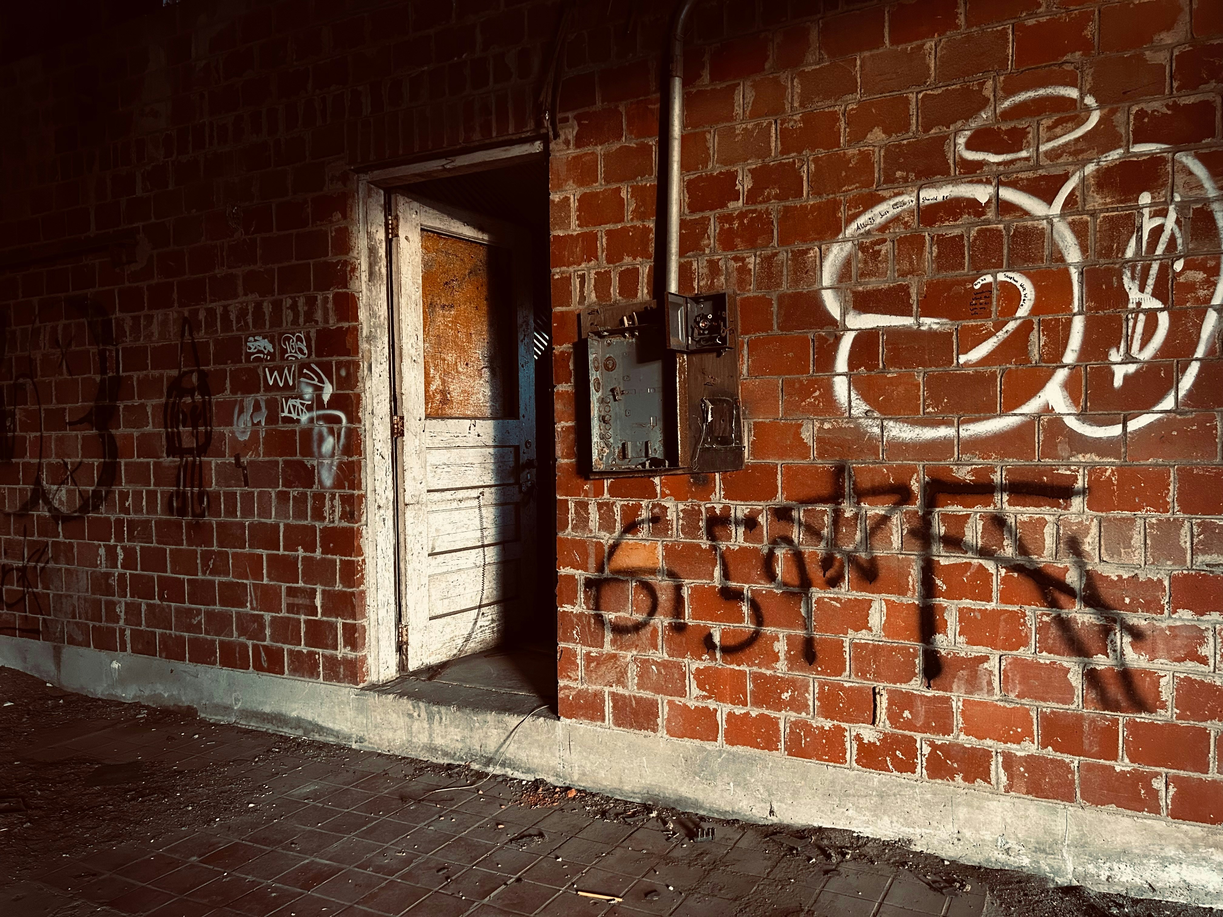 Grafiti di dinding bata di sebelah pintu terbuka