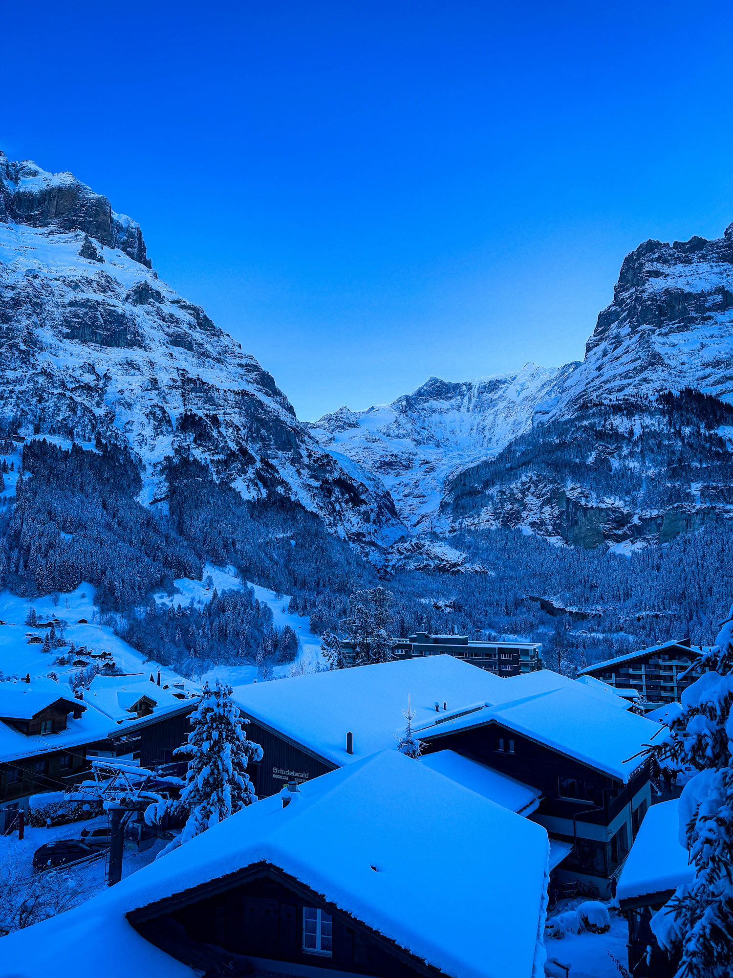 A snow-covered Alpine valley under a clear winter sky