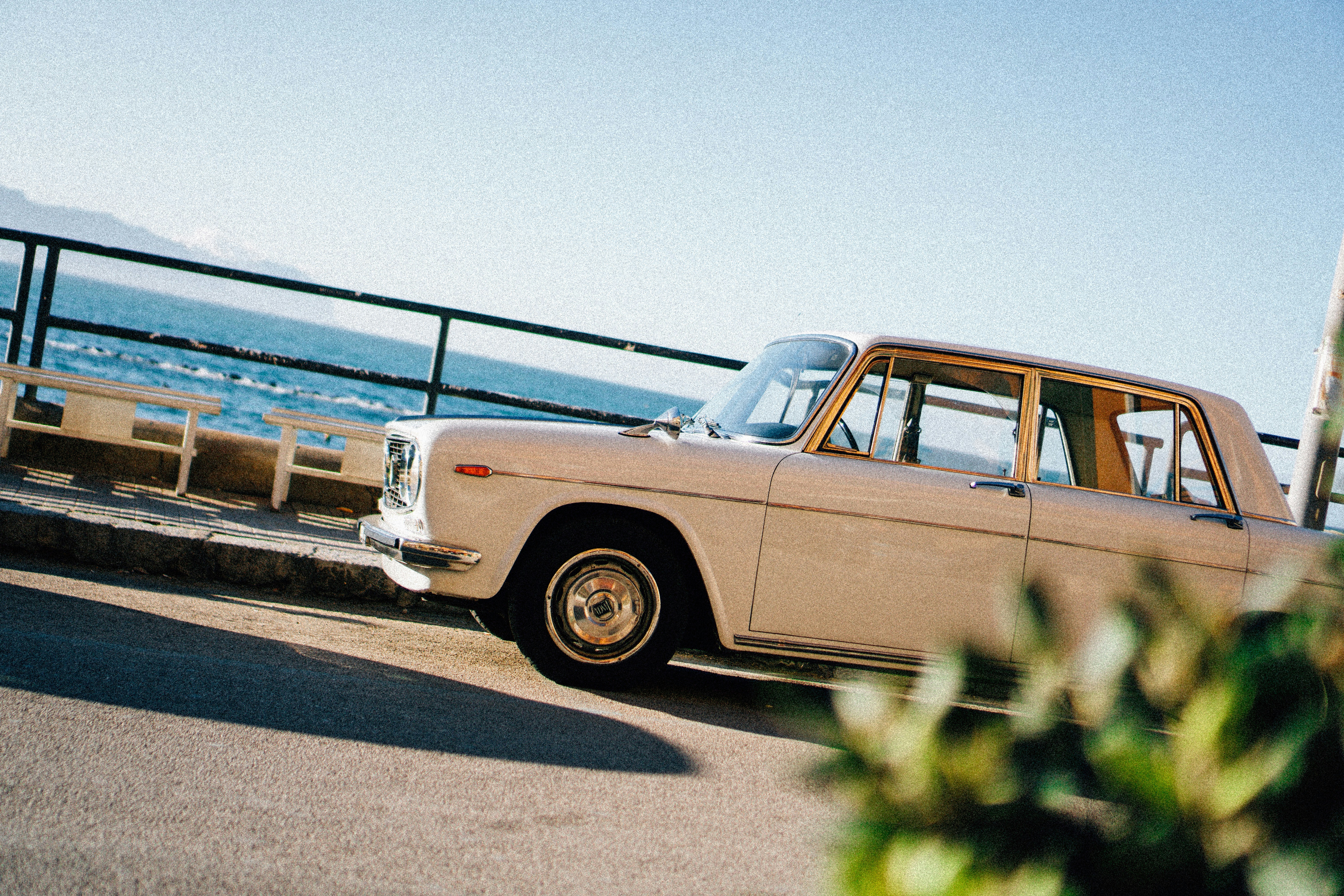Vintage car parked by the ocean on a sunny day