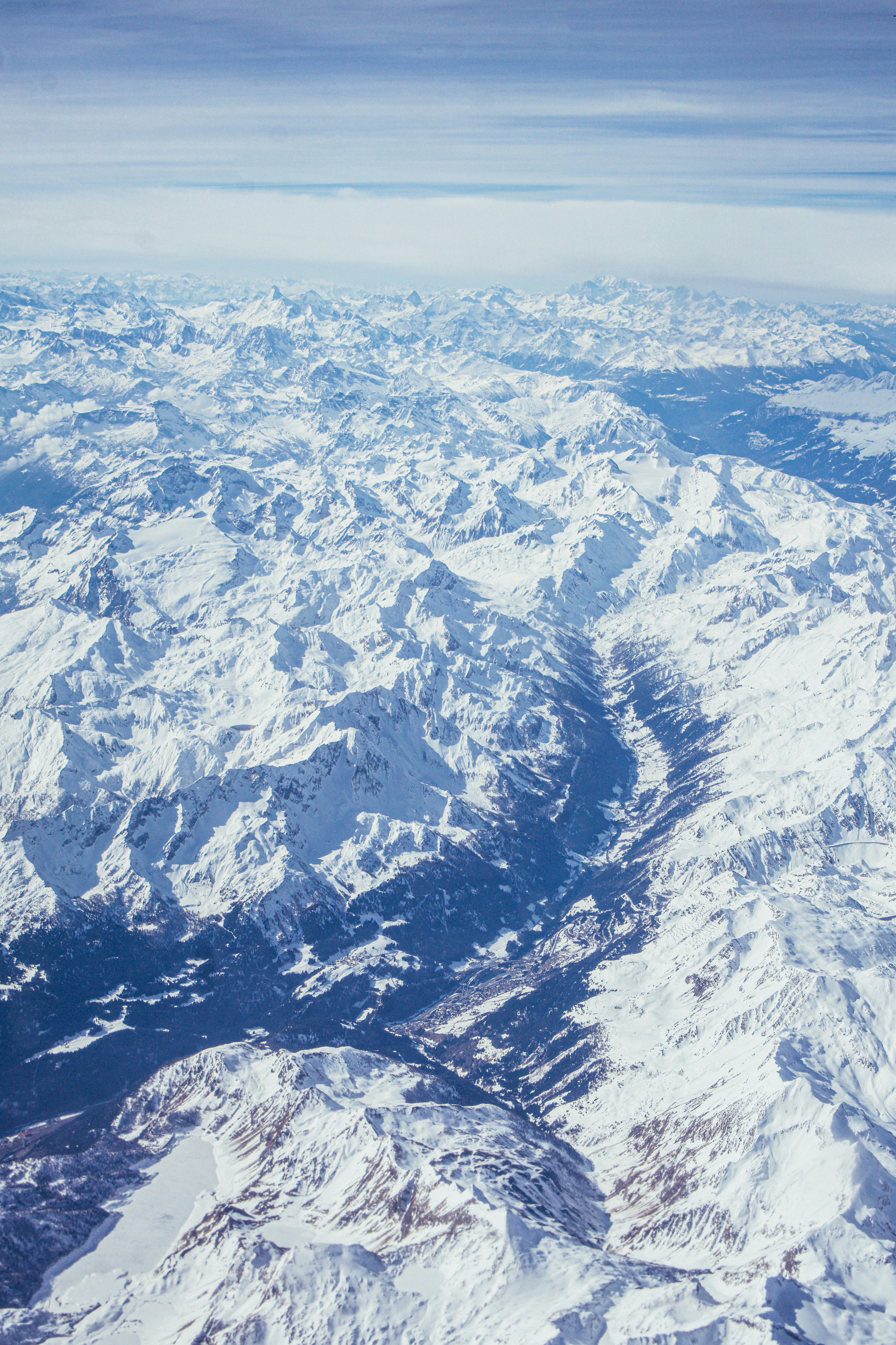 Snow-covered mountains seen from above during daytime.