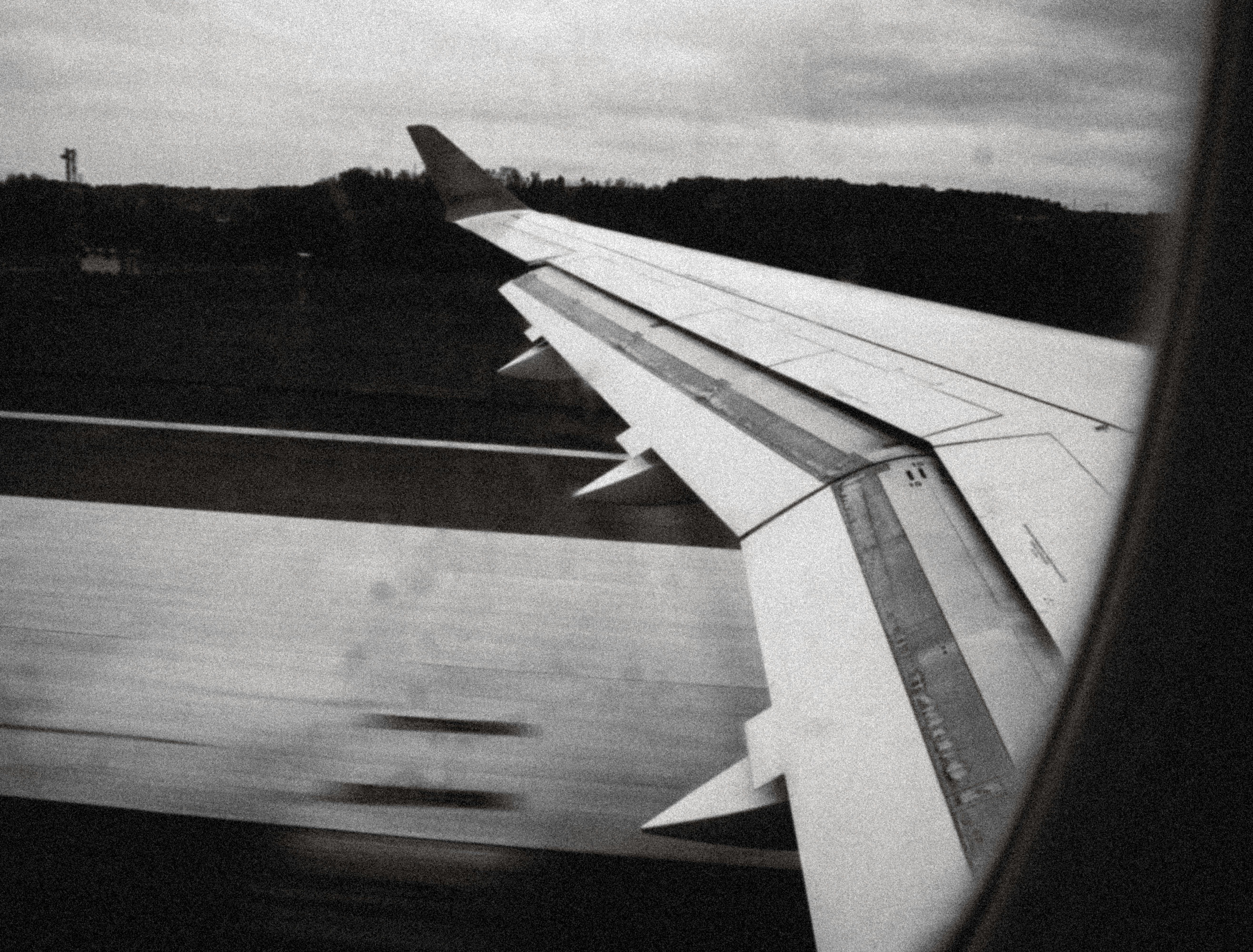 Airplane wing during takeoff over tarmac