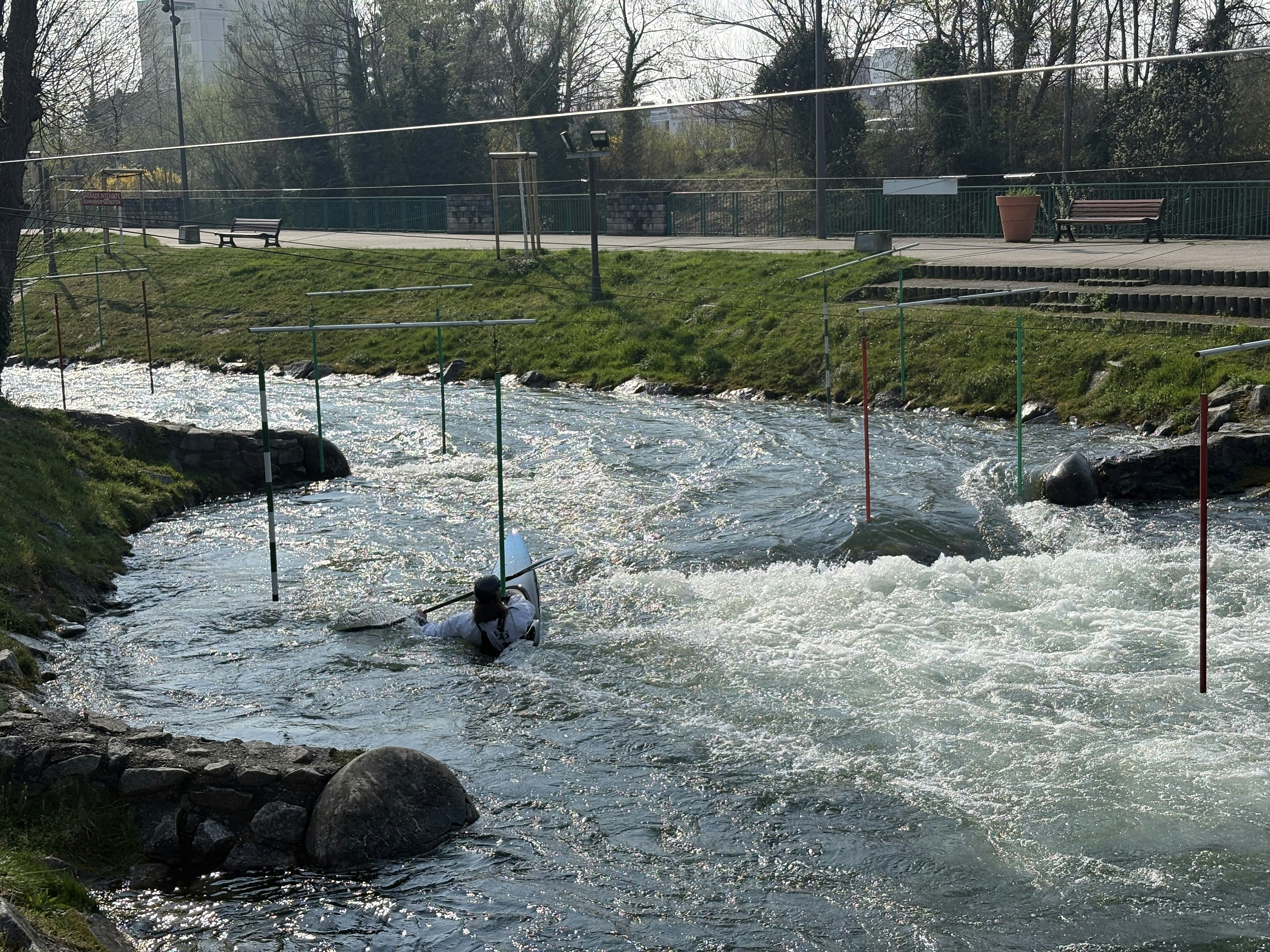 Person navigating whitewater rapids in a kayak