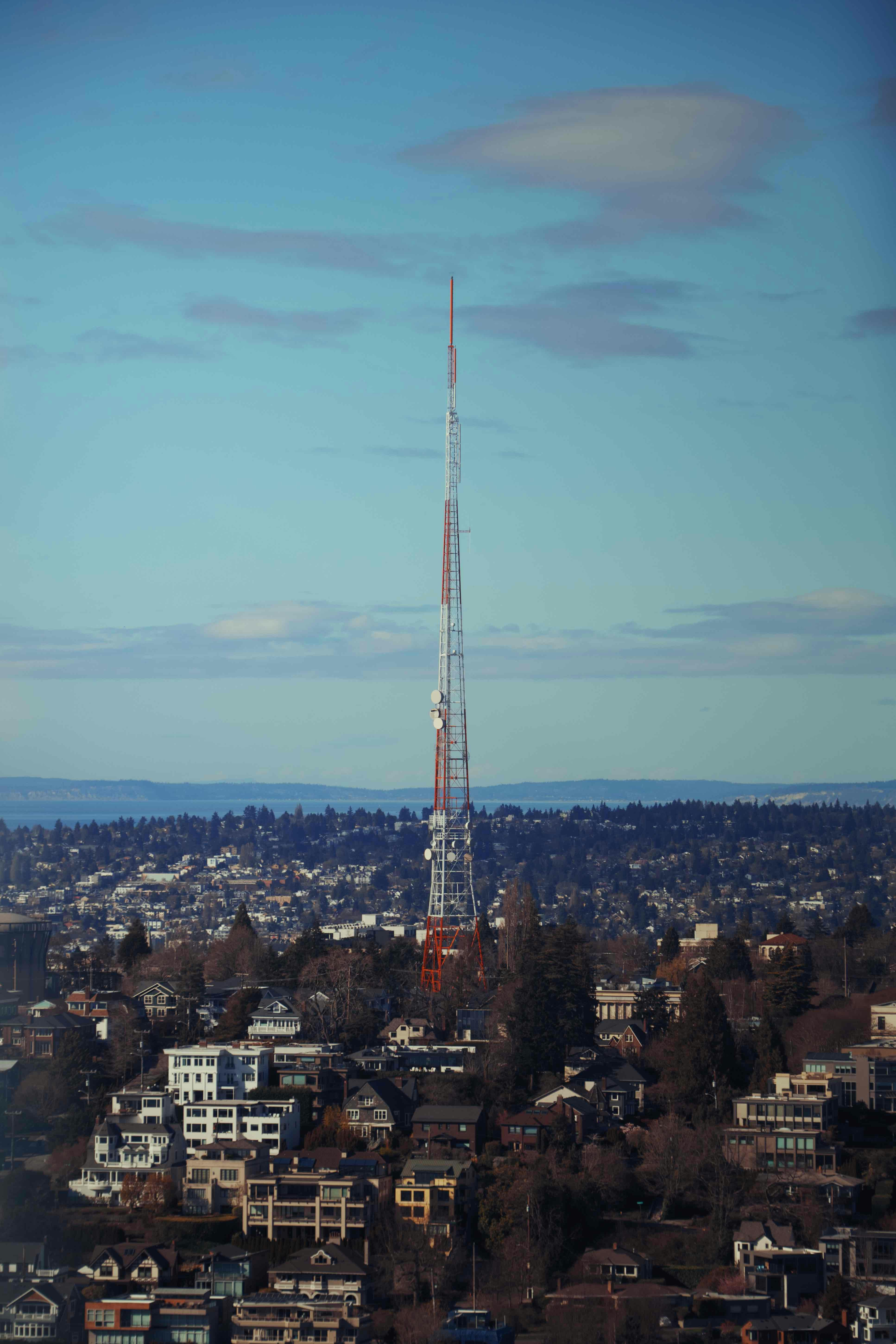 Una torre radio alta si erge sopra lo skyline di una città.