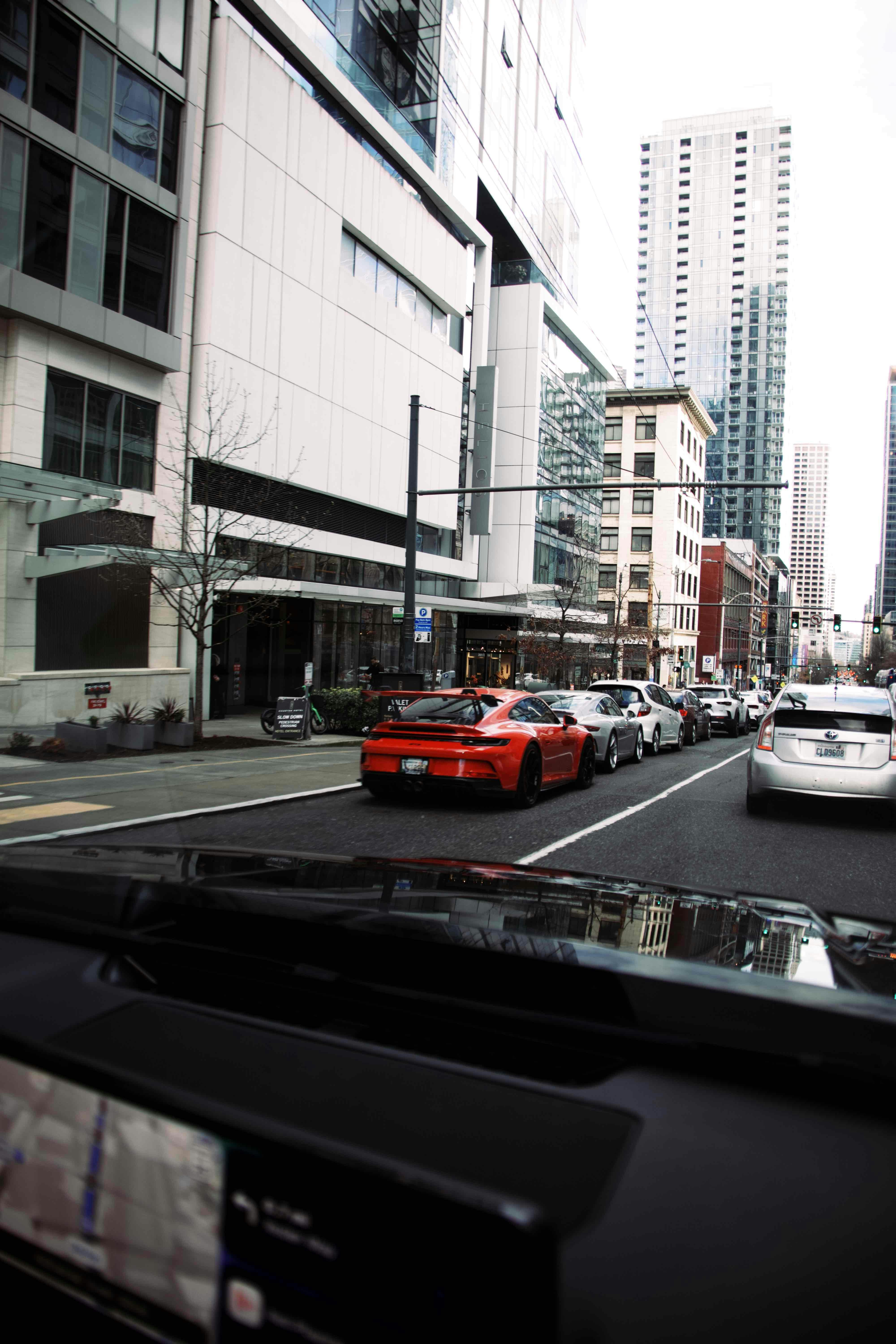 Red sports car in a city street traffic