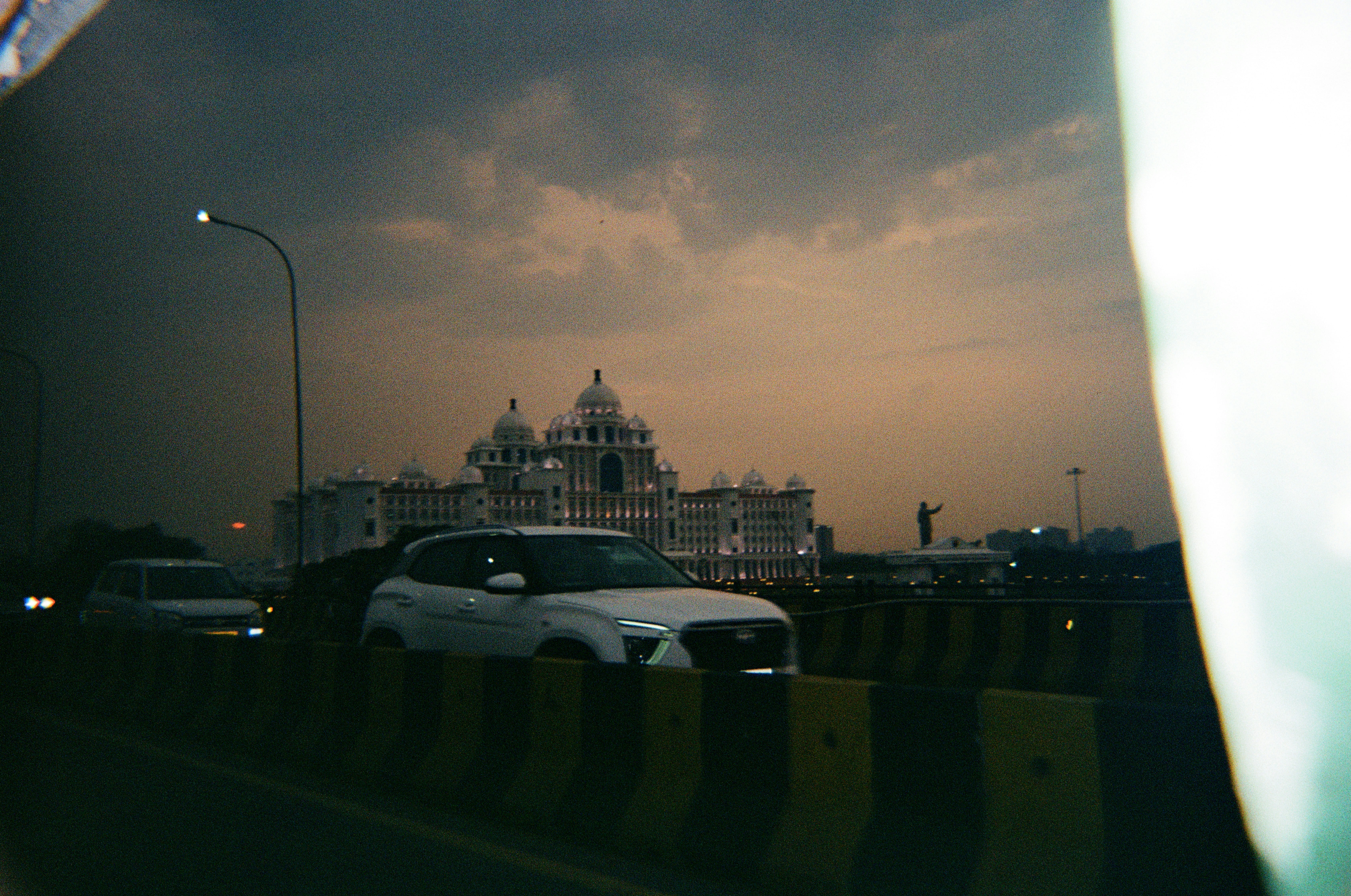 White building with cars on road at dusk