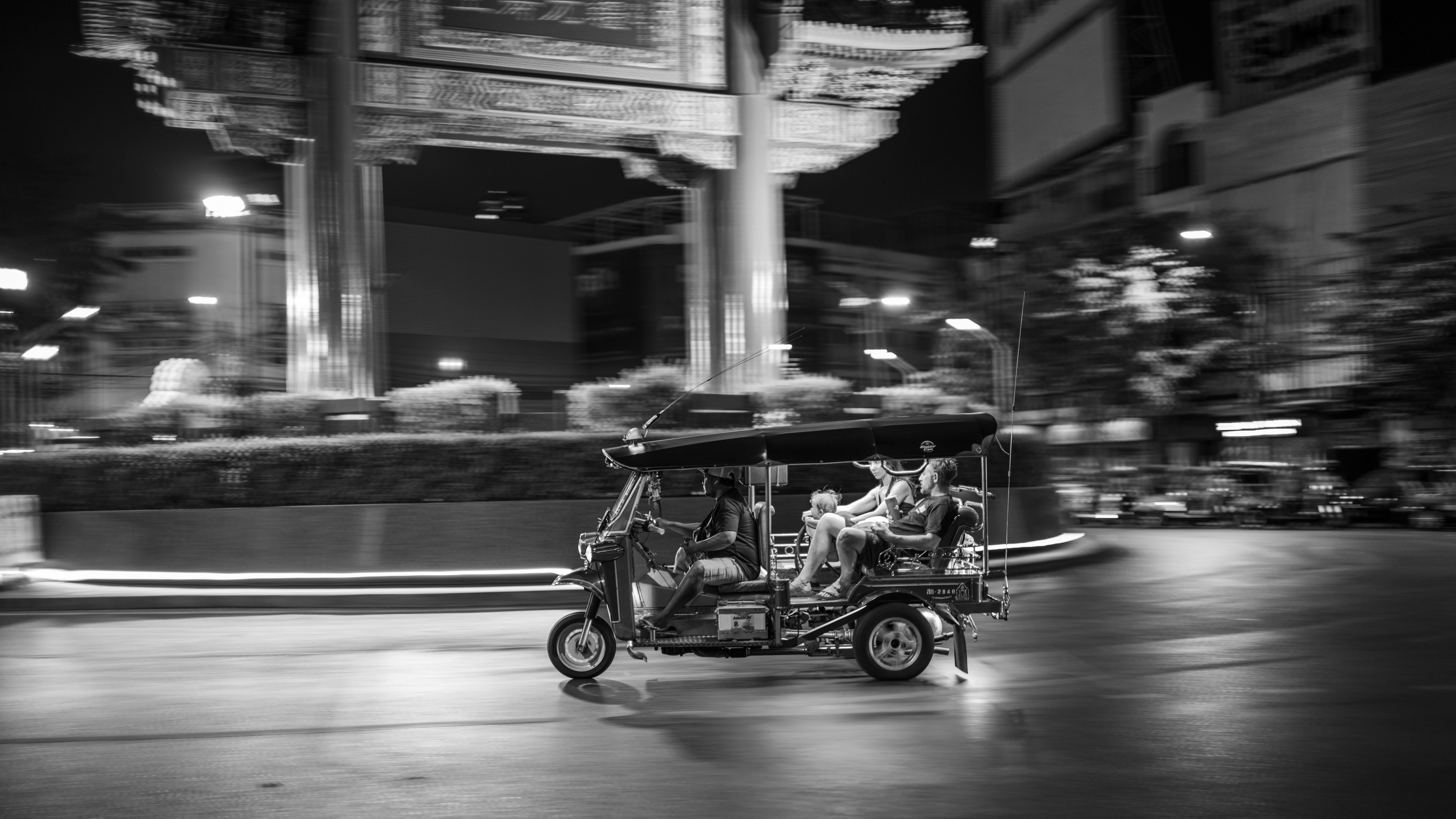 Conduciendo en tuk-tuk por una calle de la ciudad por la noche.