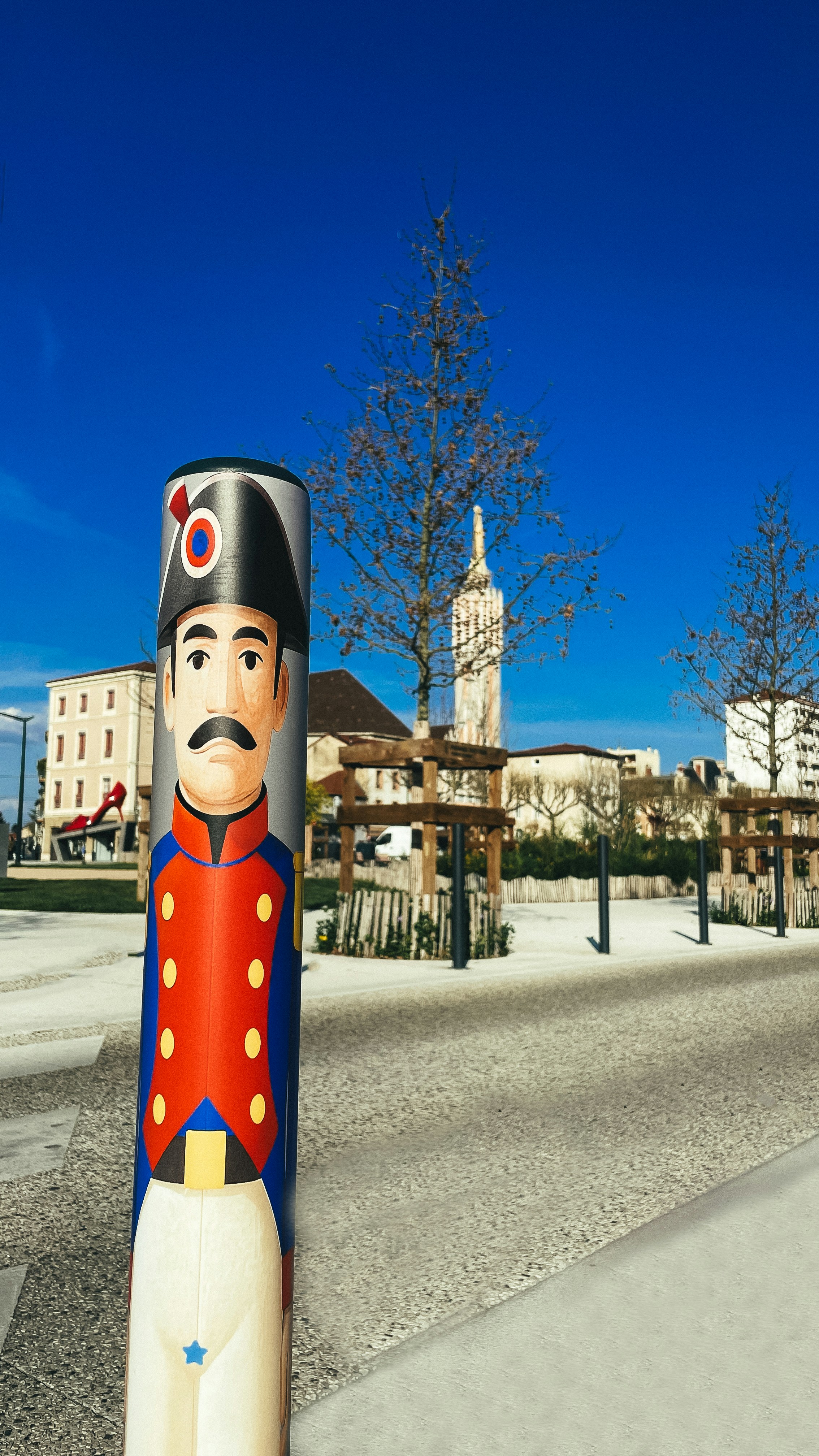 Painted soldier sculpture on a street with buildings and buildings.