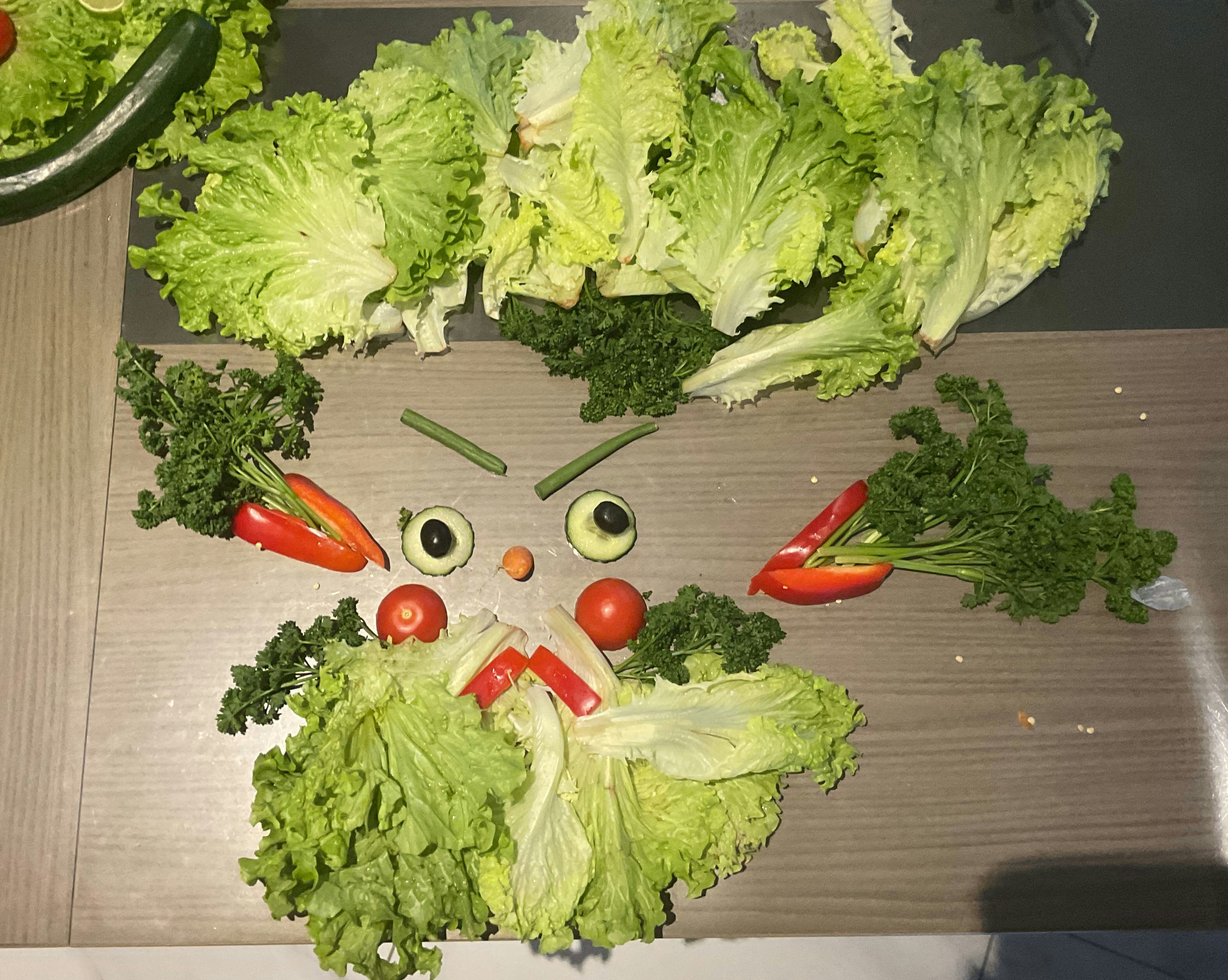 レタス、ピーマン、オリーブを使った野菜の顔