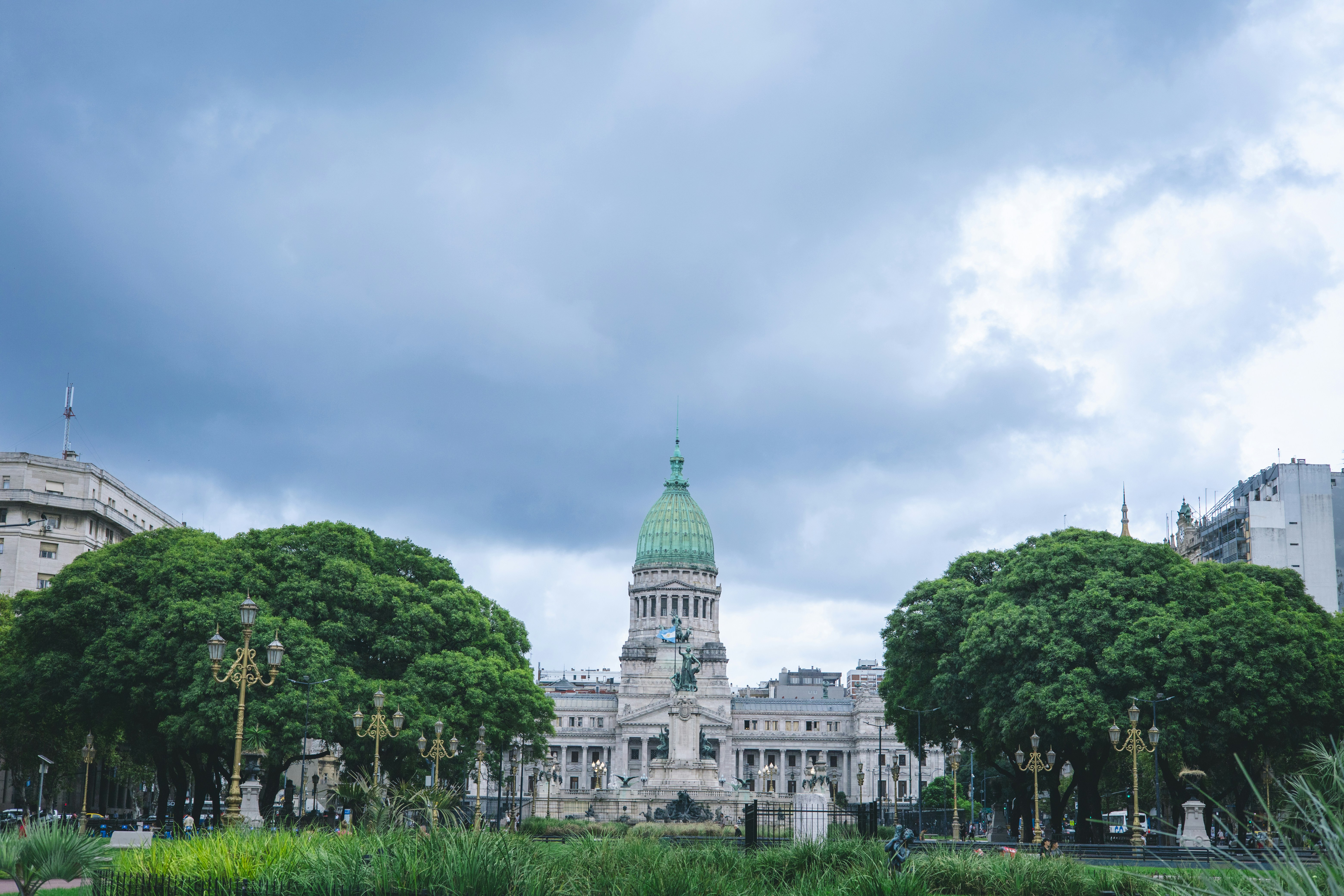 Grand building with a green dome and surrounding trees