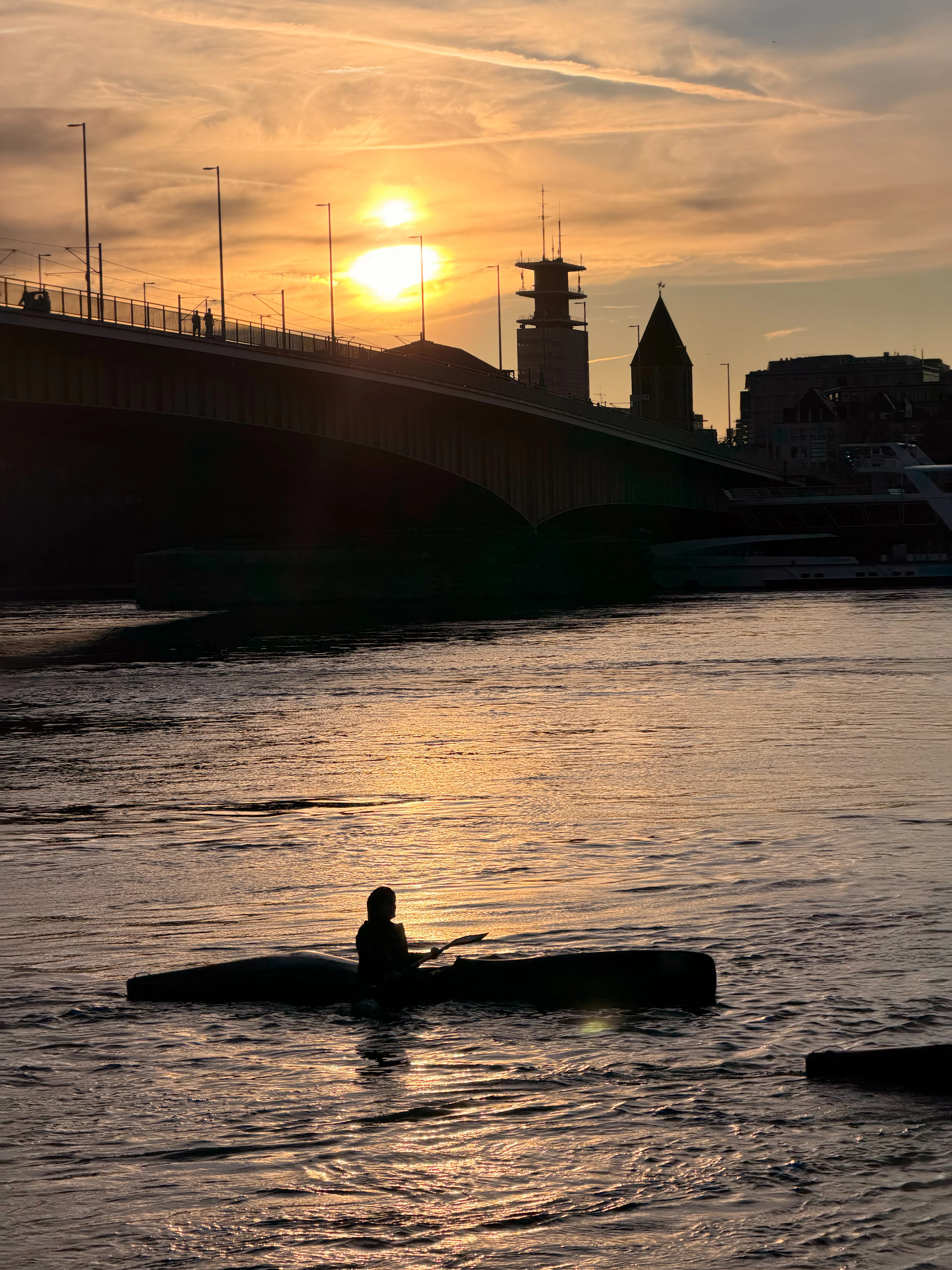 Silhouetted paddler on a canoe at golden sunset