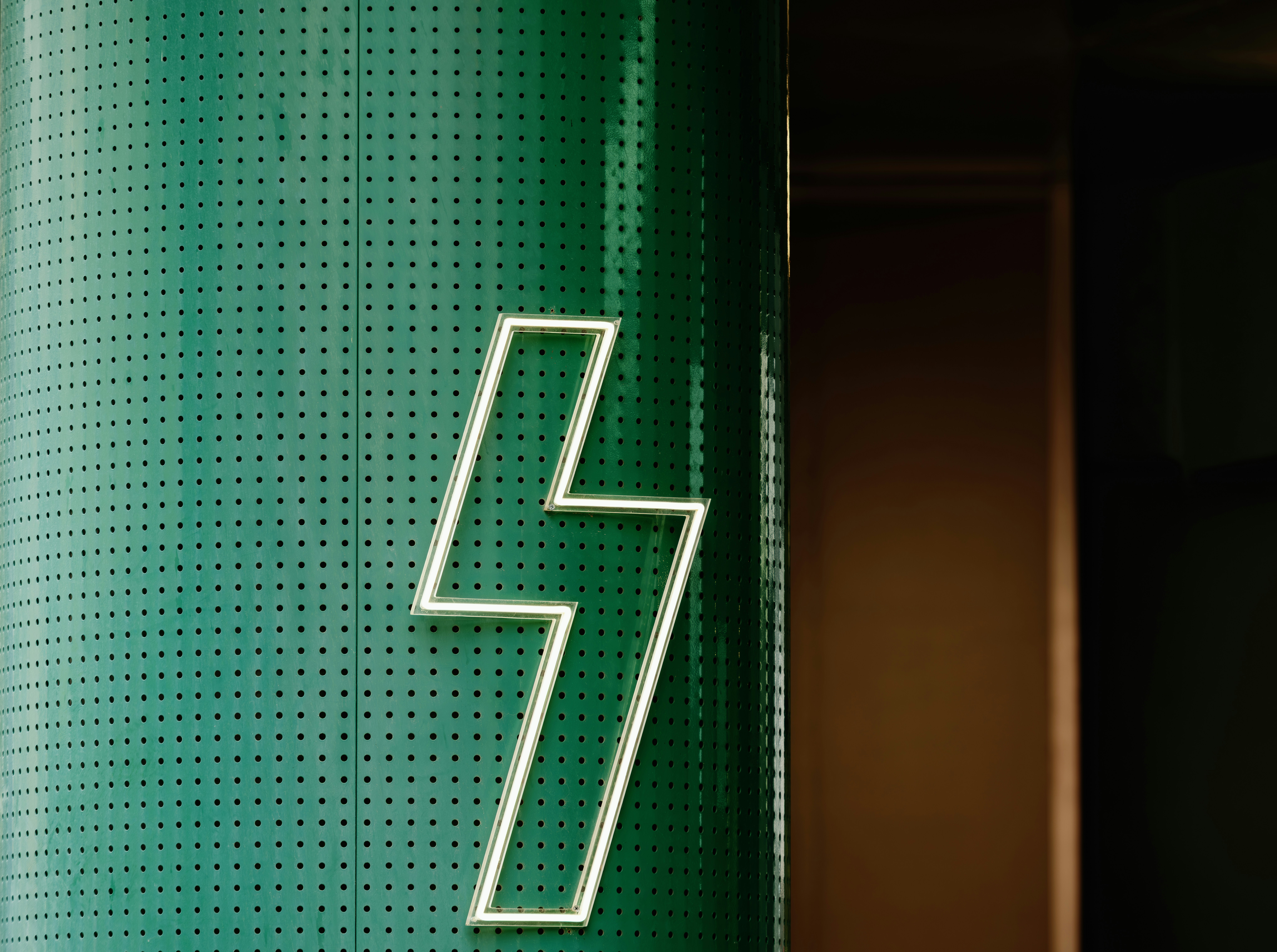 Green textured surface with a white lightning bolt symbol.