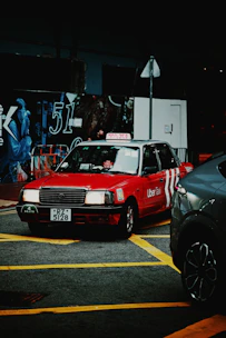 Red taxi with uber taxi logo on street at night