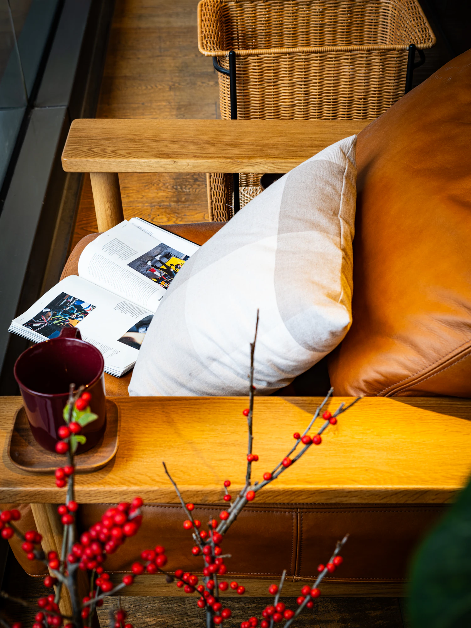 Gemütlicher Sessel mit Buch, Kissen und Tasse als Symbol für einen neuen rauchfreien Abendanker