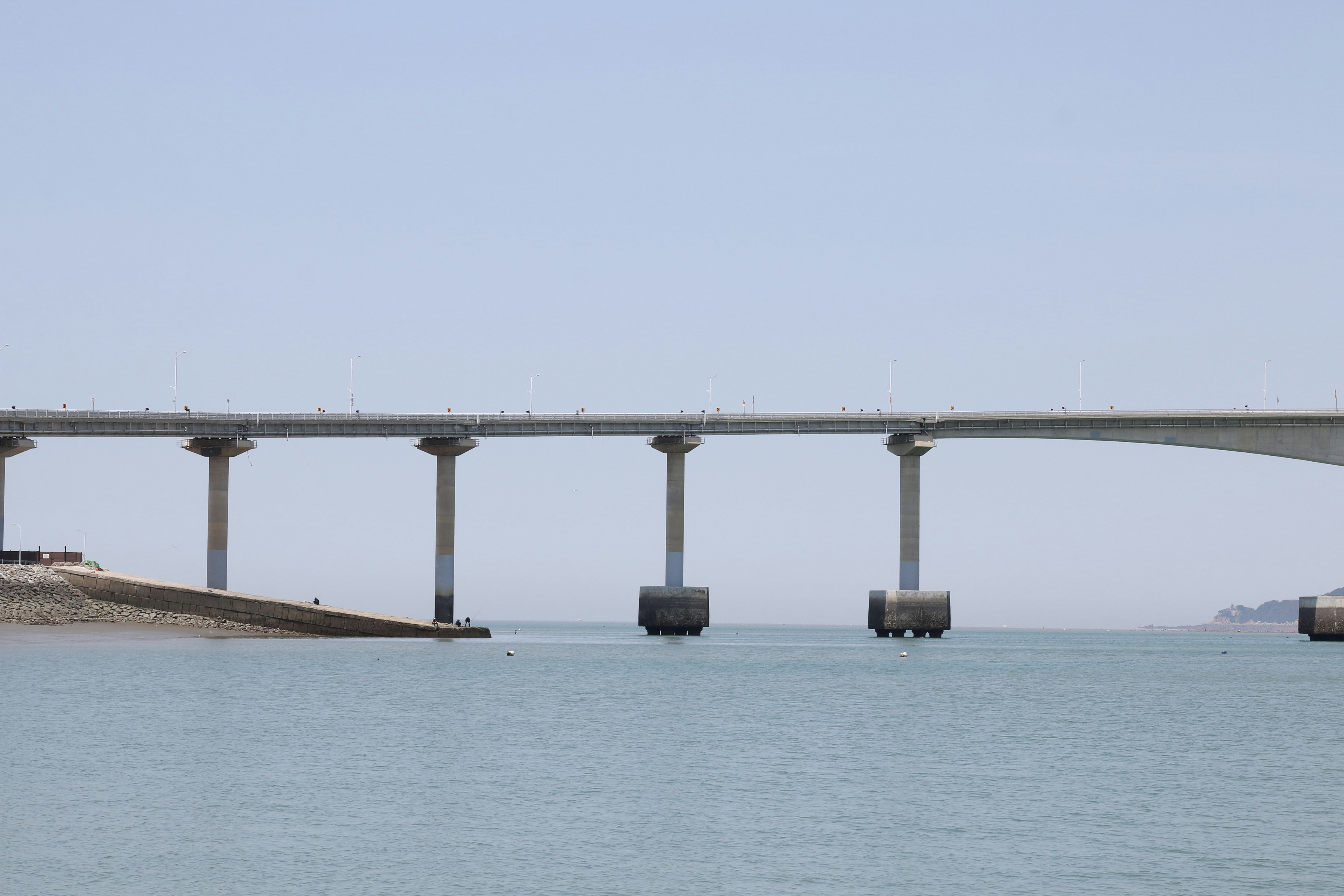 Un lungo ponte di cemento sopra acque calme