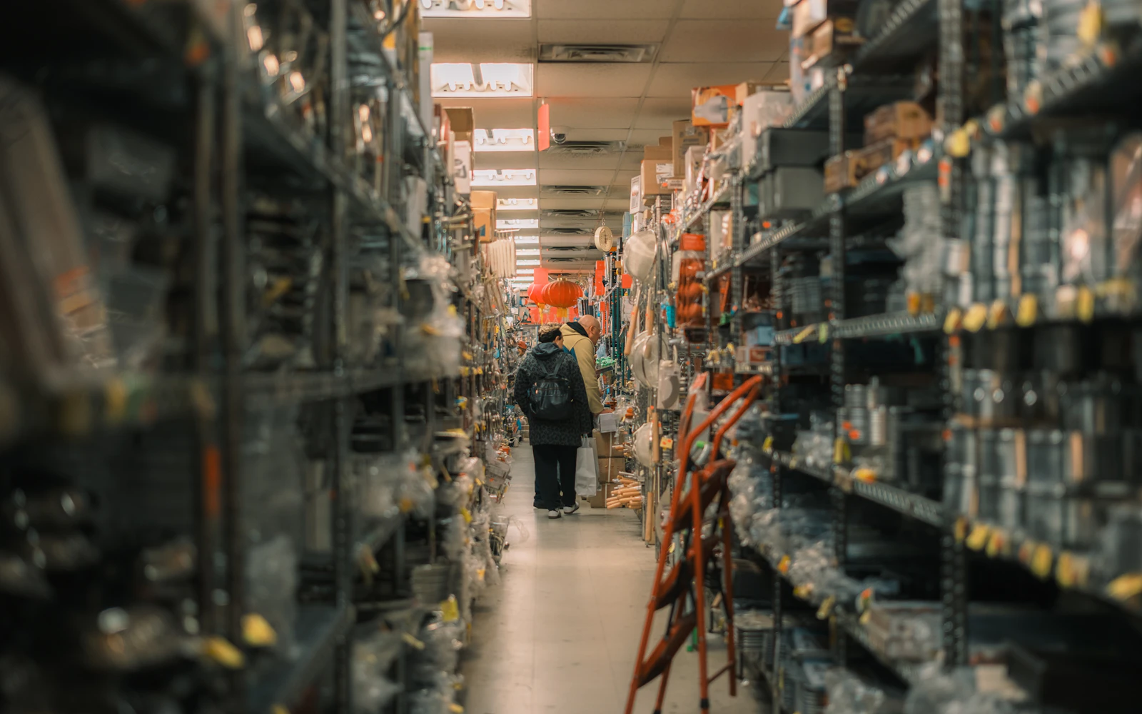 Person walking through a stocked warehouse aisle