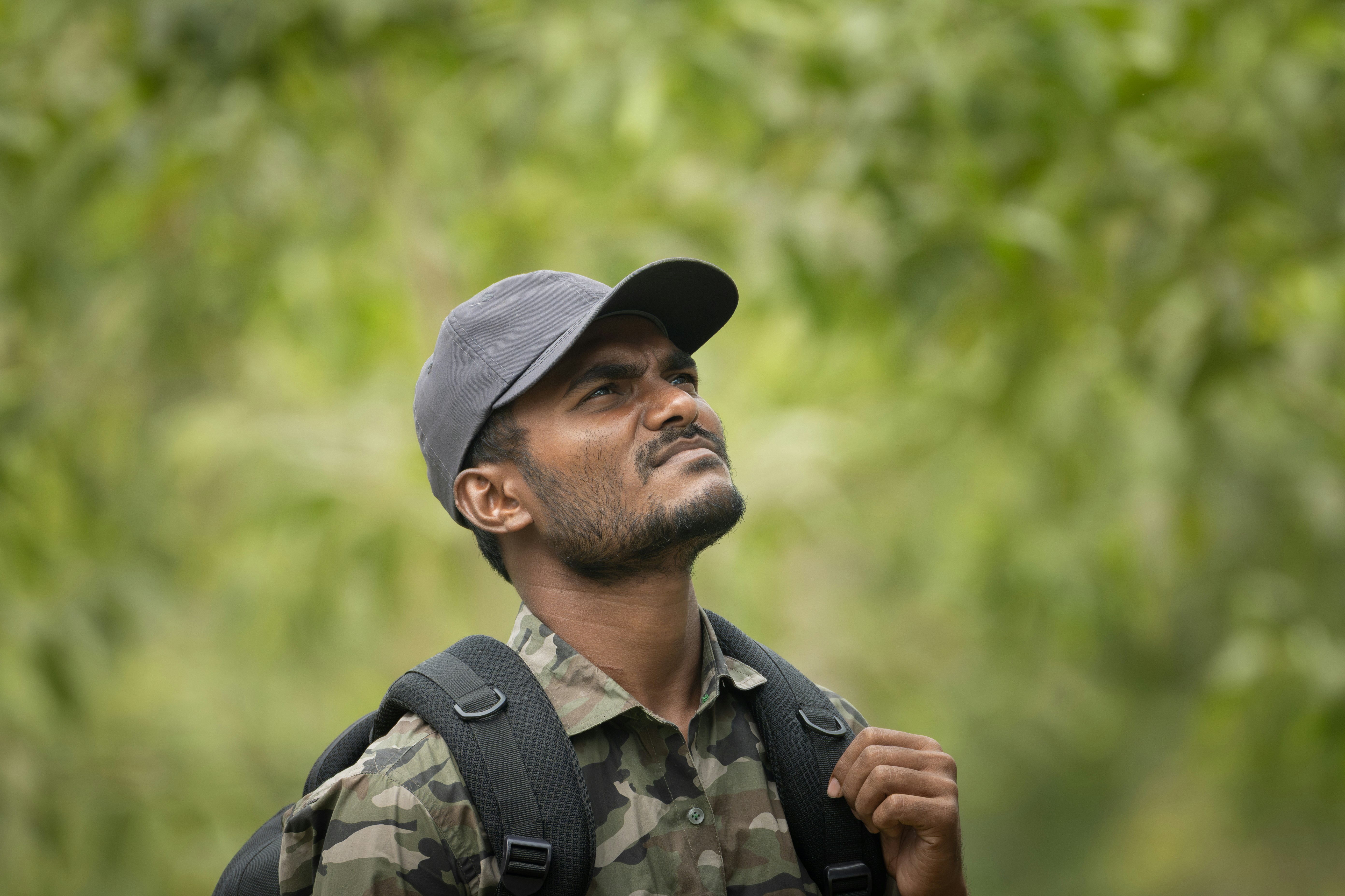 Man in camouflage looking up with backpack