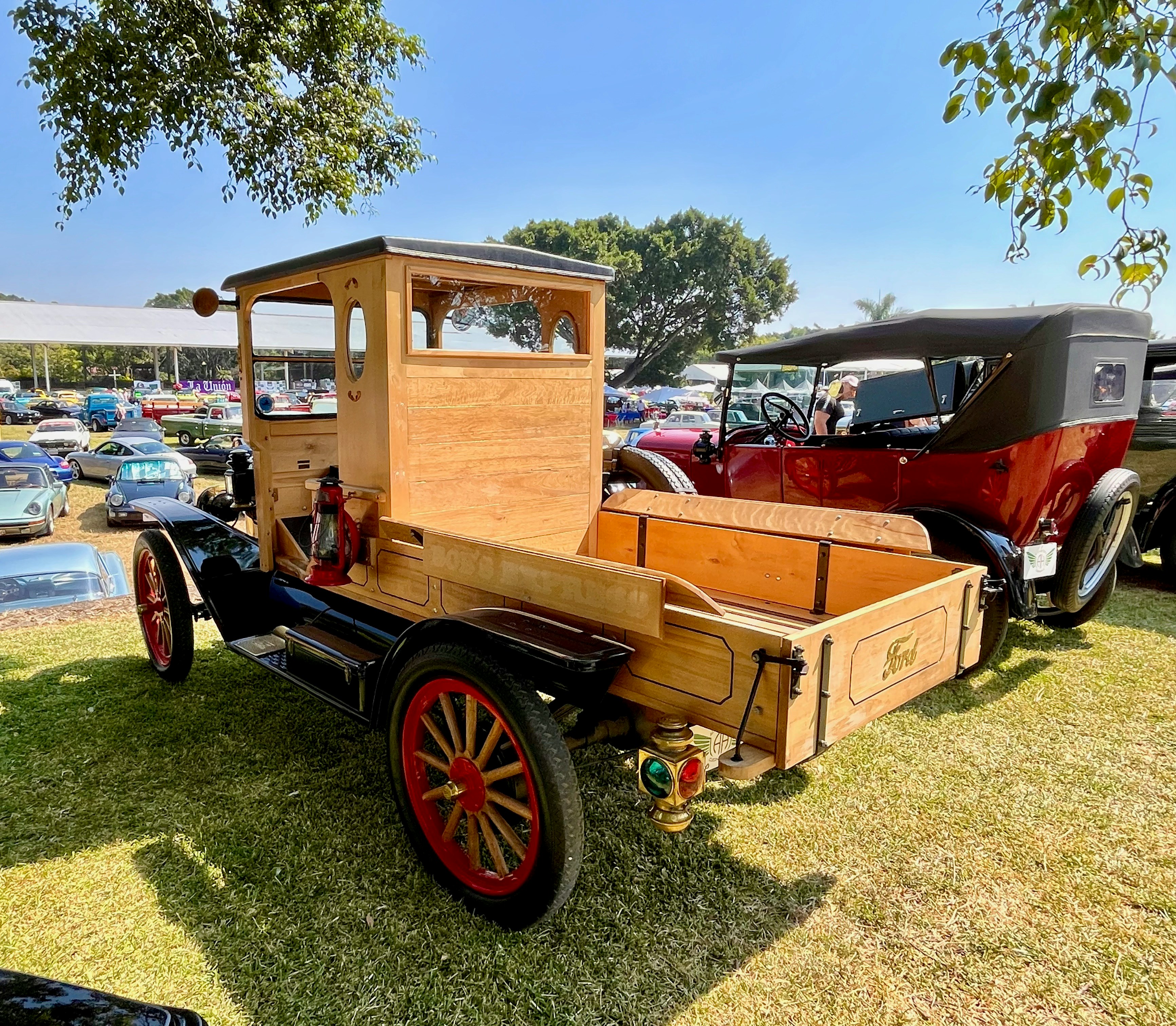 Camion en bois ancien avec roues rouges sur l’herbe