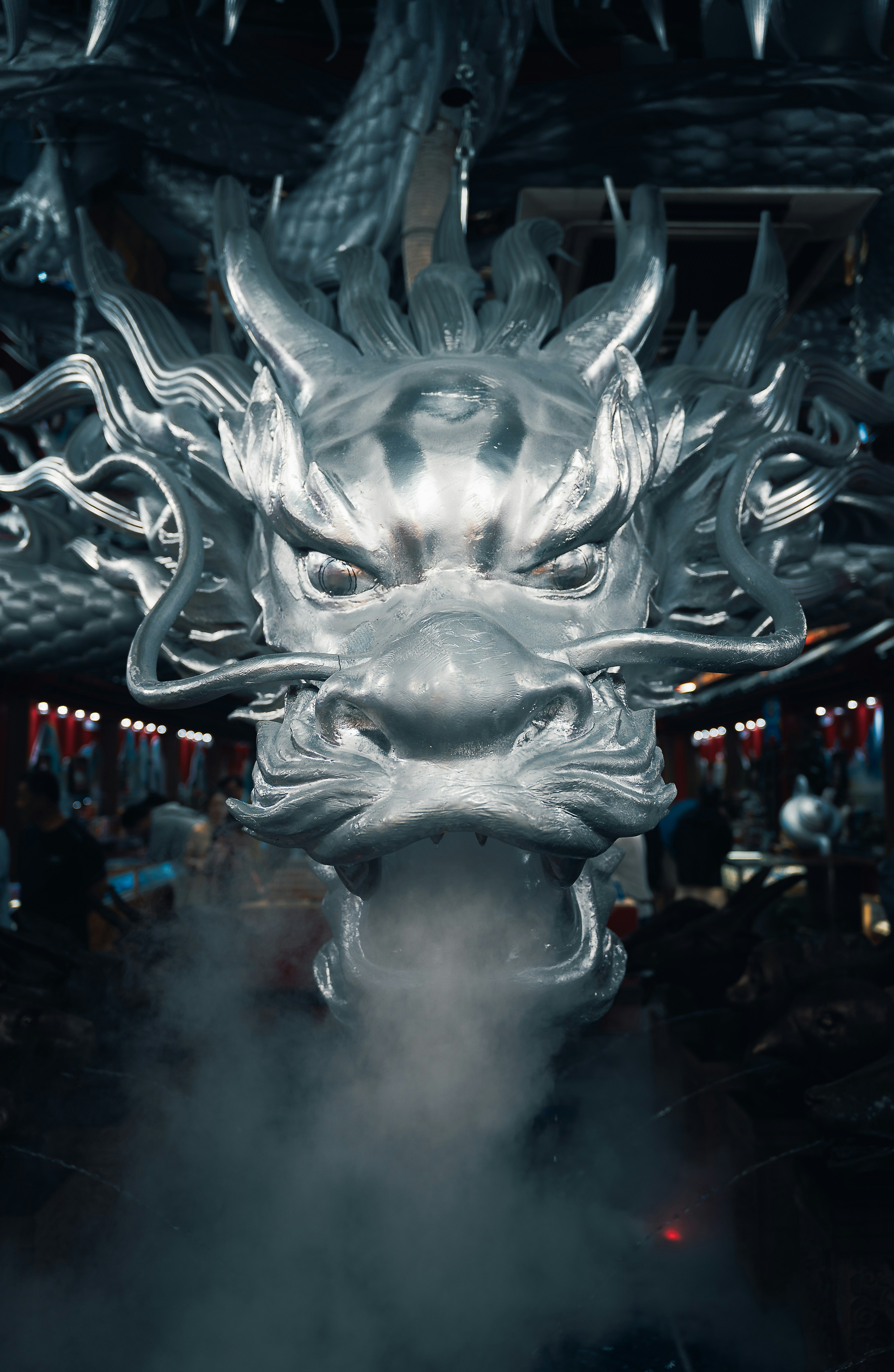 Uma cabeça de dragão prateada detalhada exala fumaça.