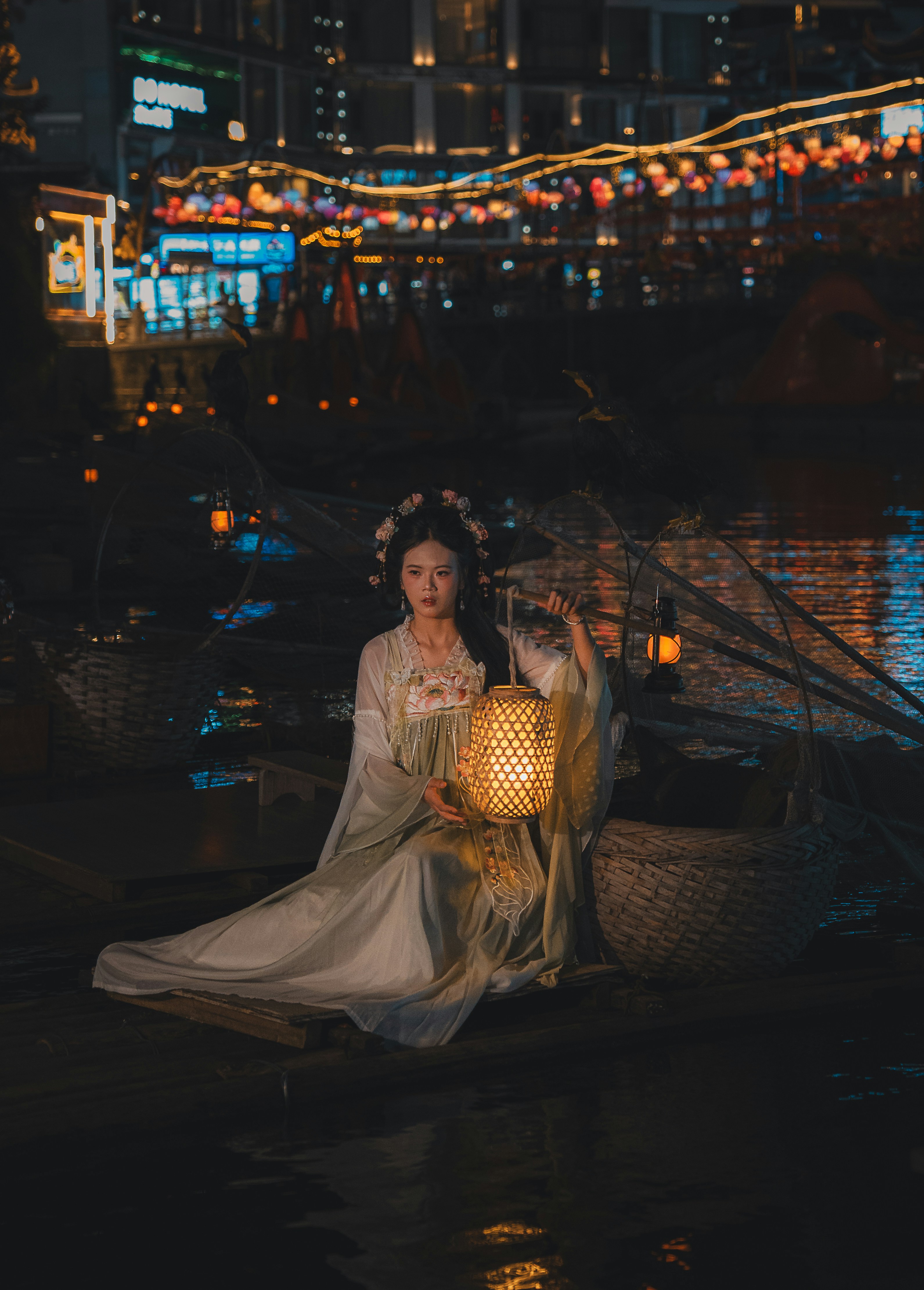 Mulher em traje tradicional segurando lanterna no barco à noite
