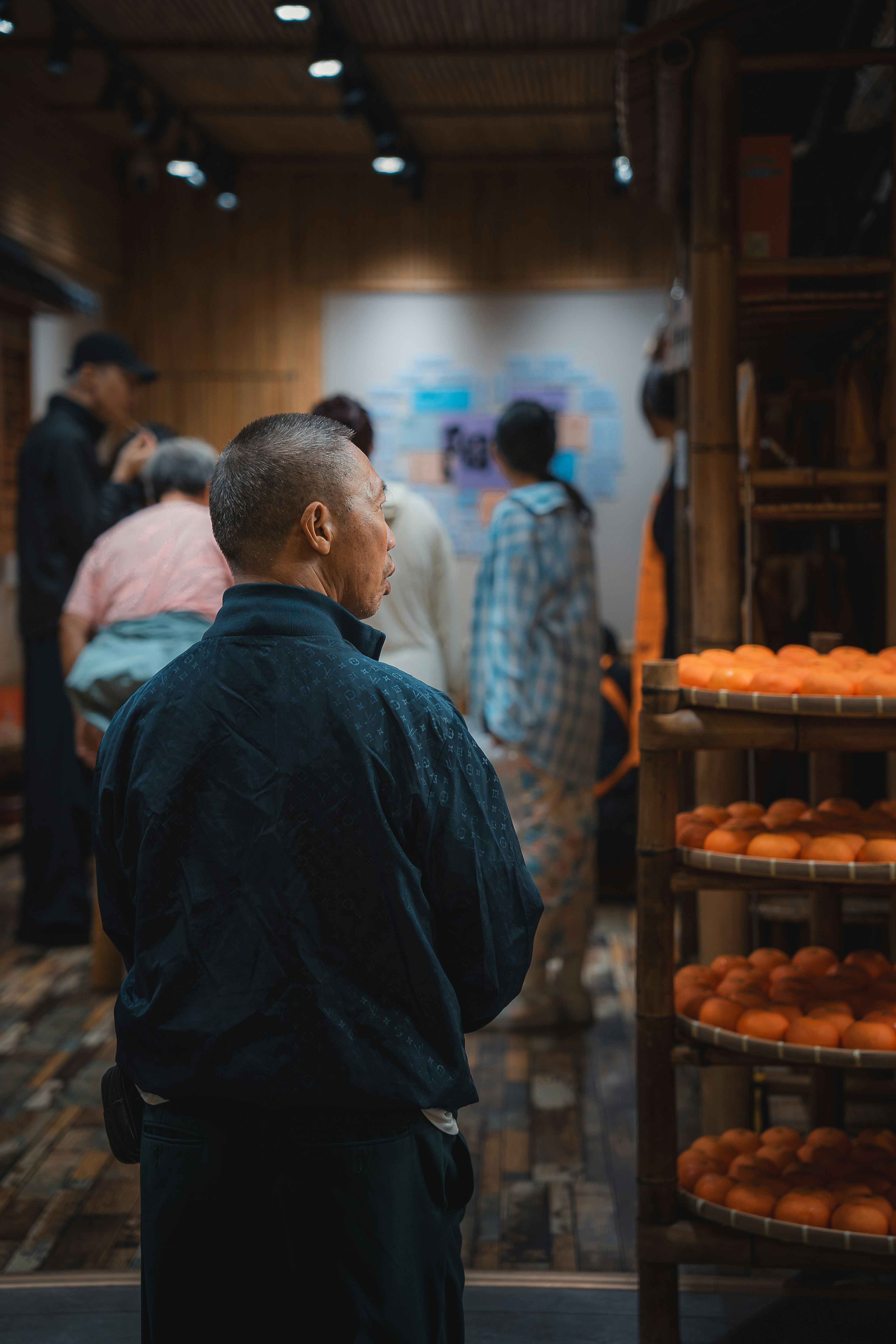 Homem olhando para a tela com pessoas ao fundo